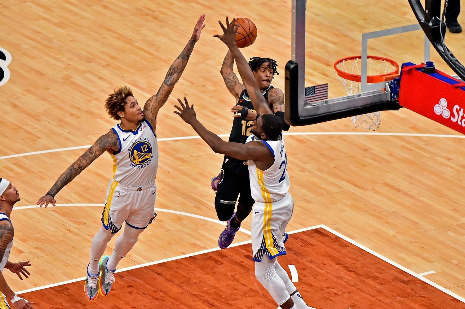 Memphis Grizzlies star Ja Morant dunks over Kelly Oubre Jr. and Draymond Green of the Golden State Warriors in a game on March 19, 2021.