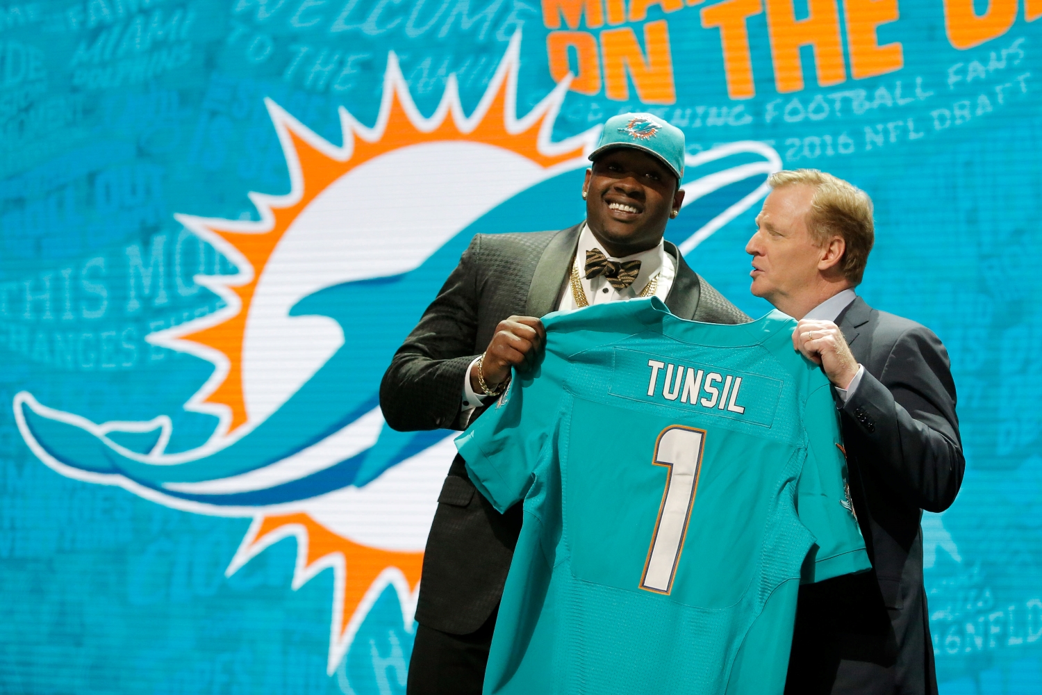Laremy Tunsil holds up his Dolphins jersey with Roger Goodell after he got selected in the first round of the 2016 NFL draft.