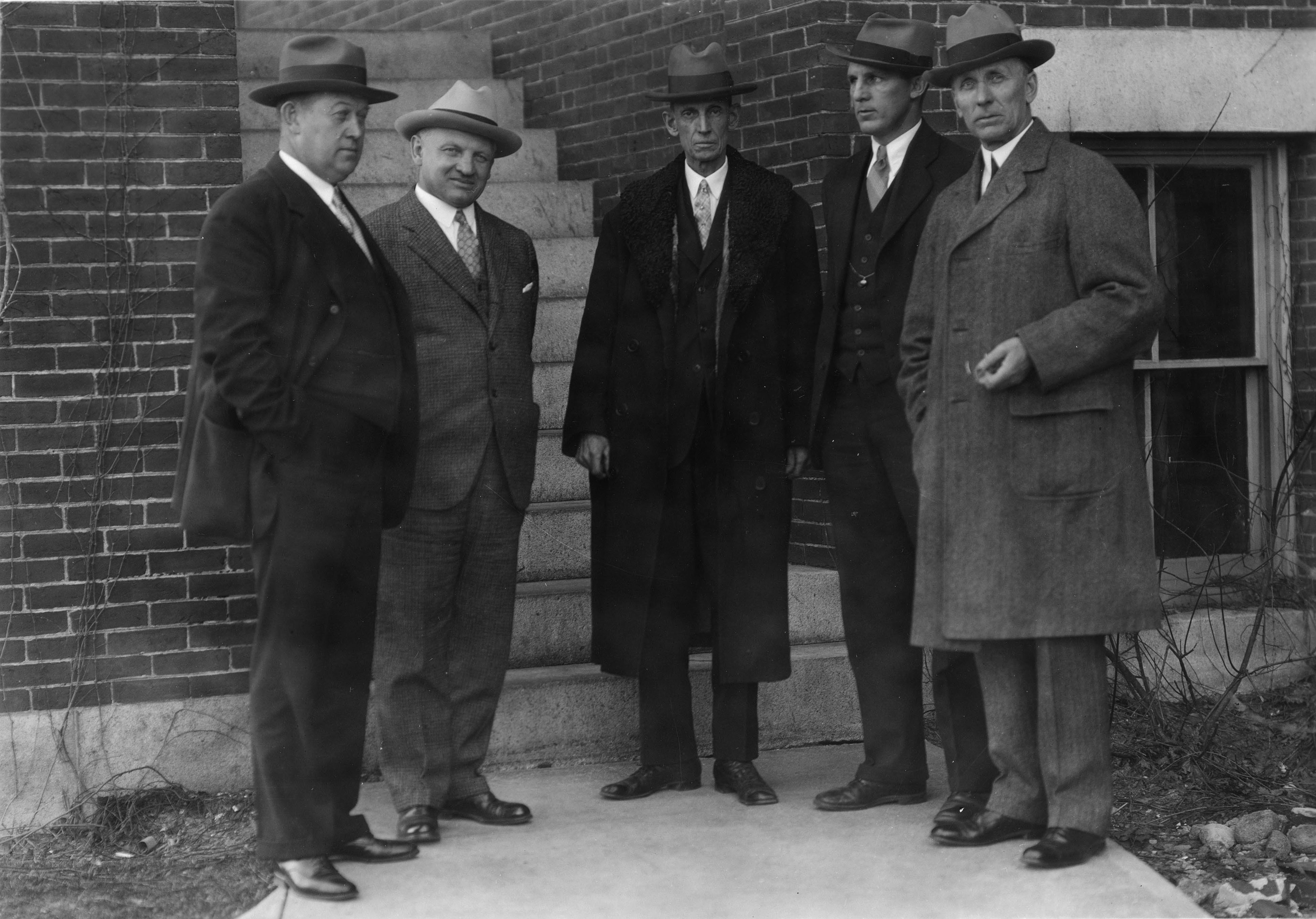 Coaches William "Butch" Cowell, Hugo Bezdek, and Ernest Christensen stands with Edward Lewis