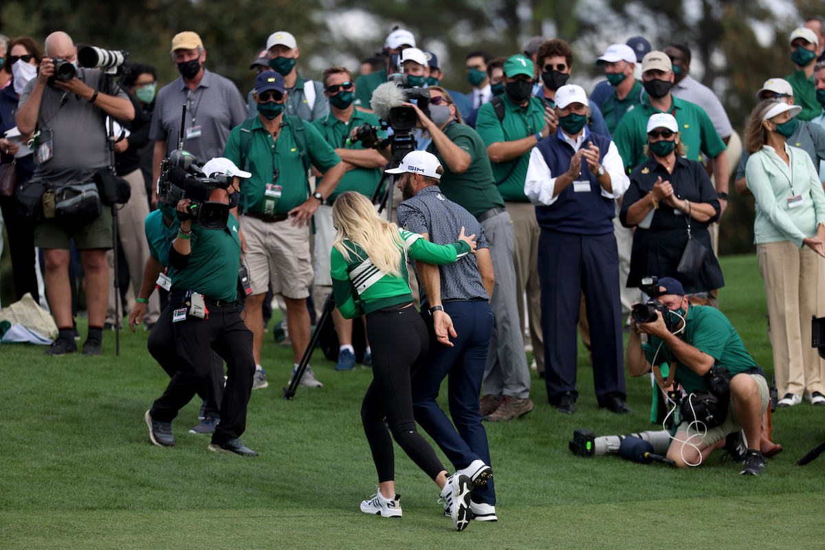 Dustin Johnson walks off the green with fiancée Paulina Gretzky after winning the 2020 Masters
