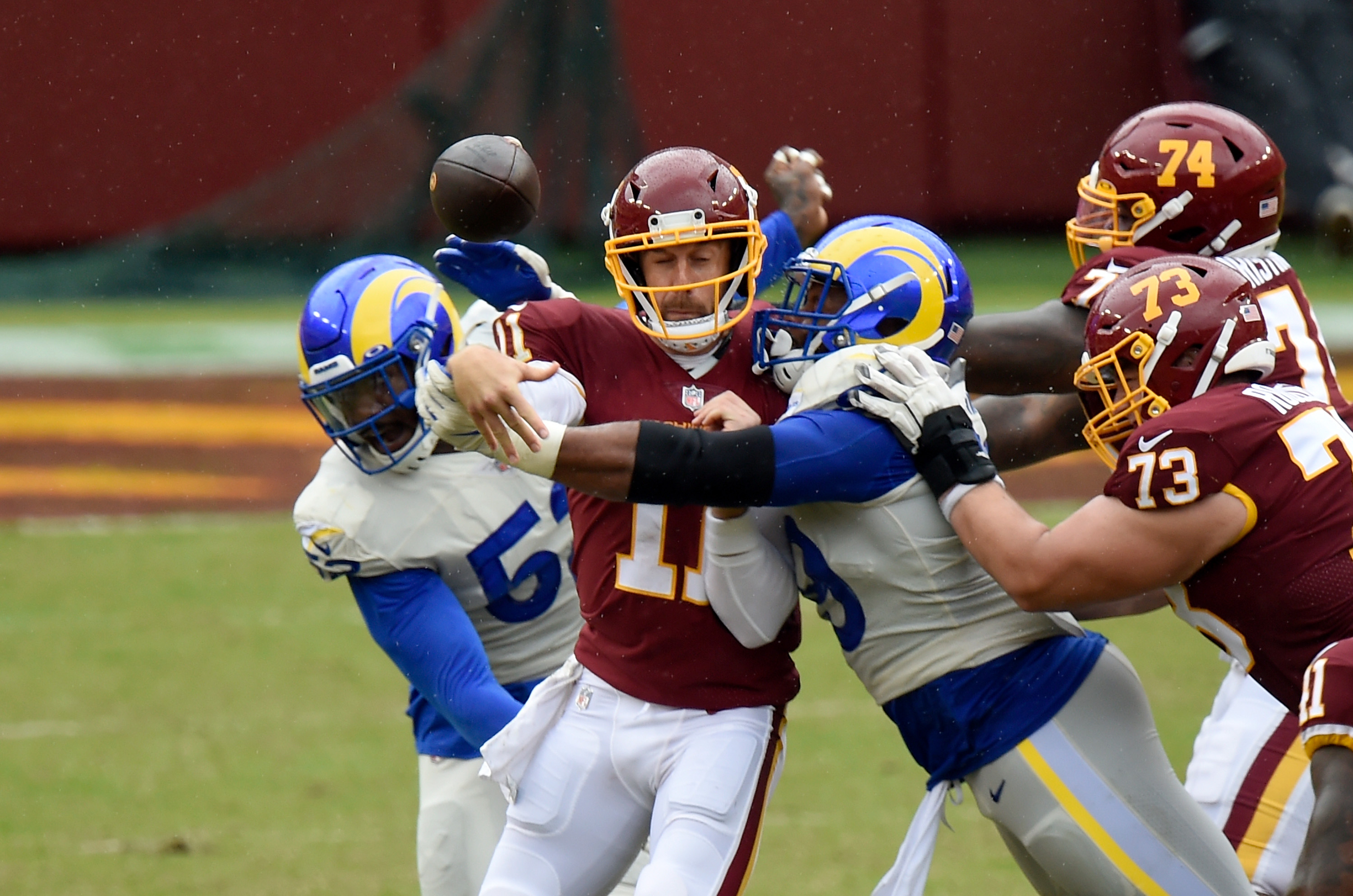 Alex Smith of the Washington Football Team is hit by Aaron Donald of the Rams