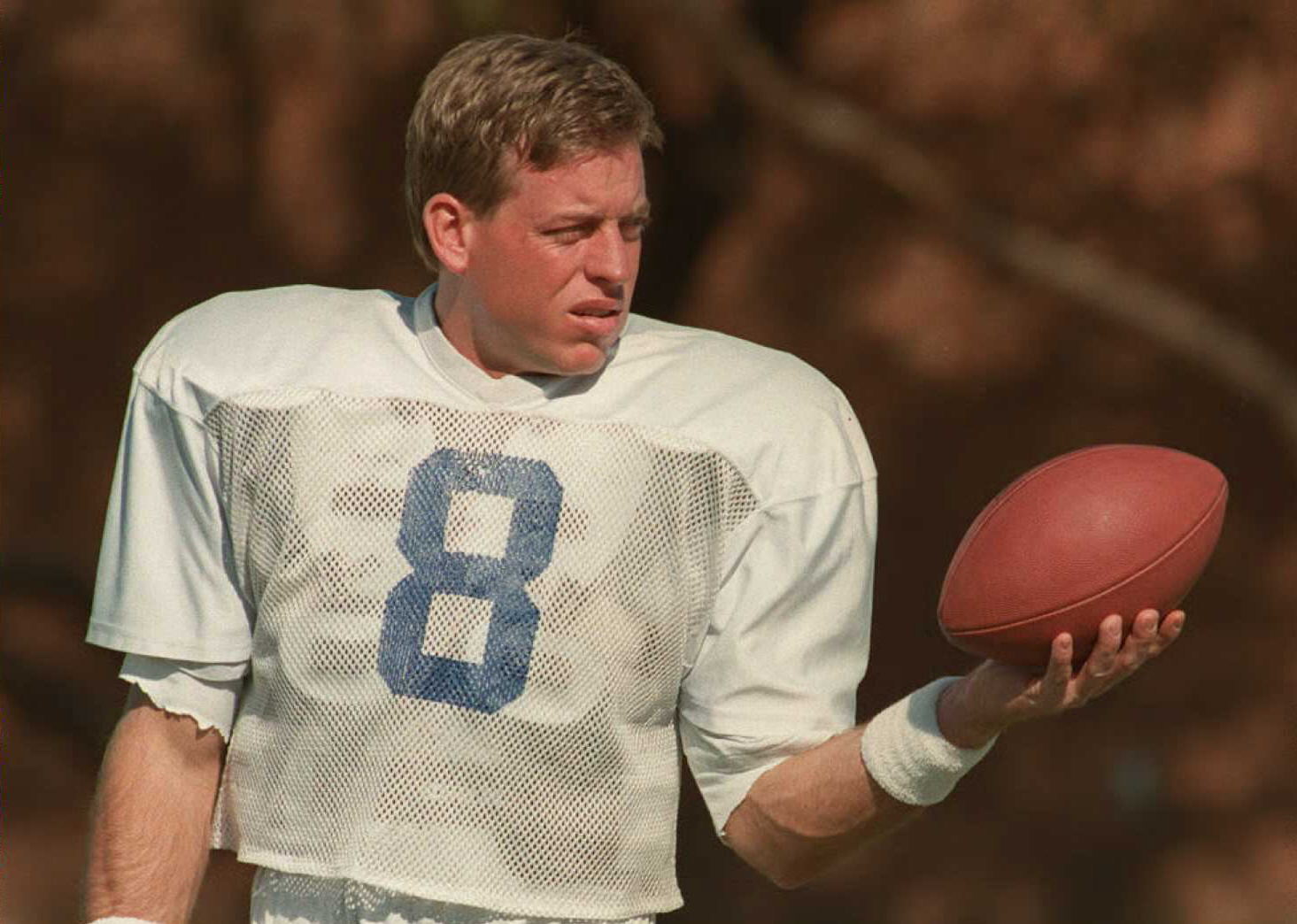 Troy Aikman holds a football during a workout