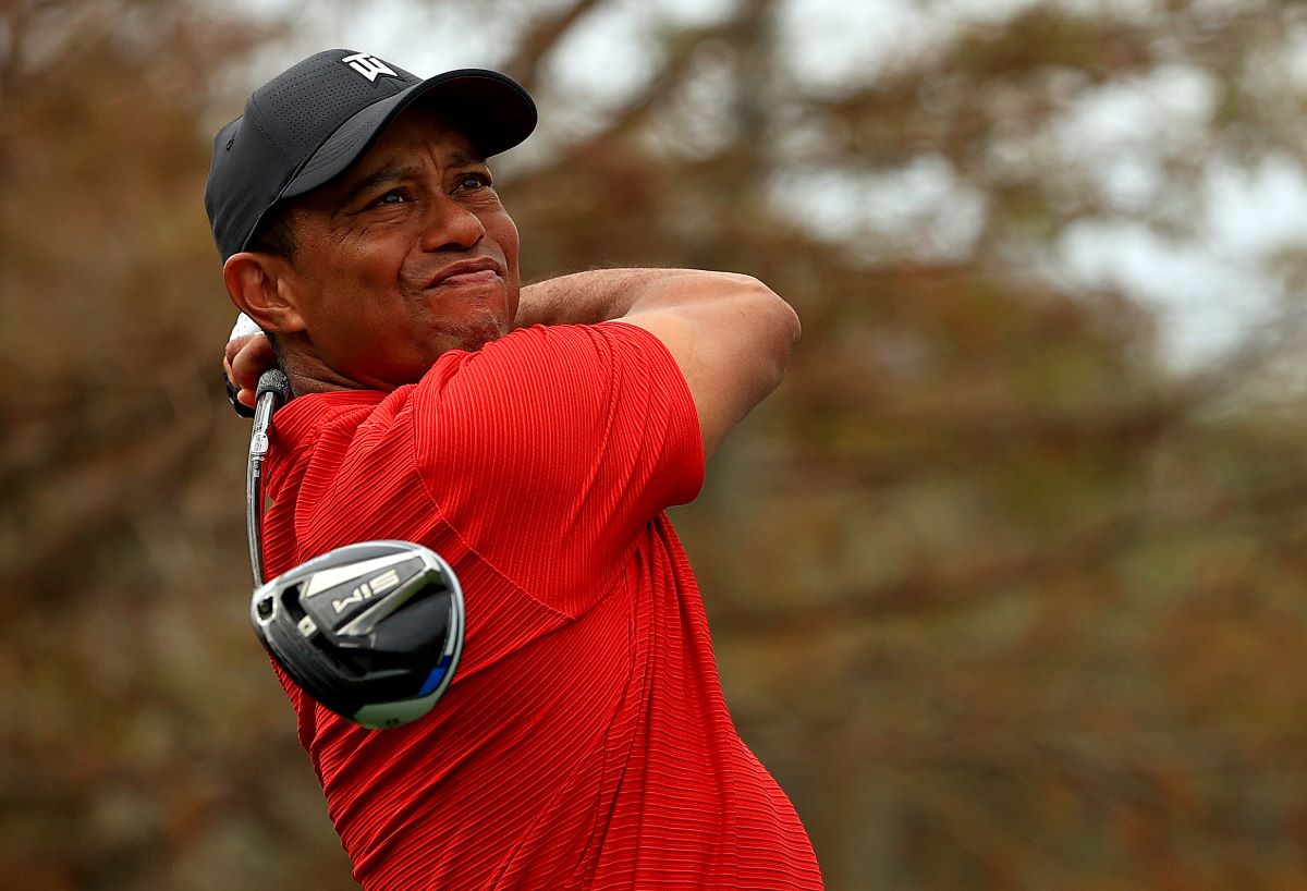 Tiger Woods squints down the course as he hits a tee shot in 2020