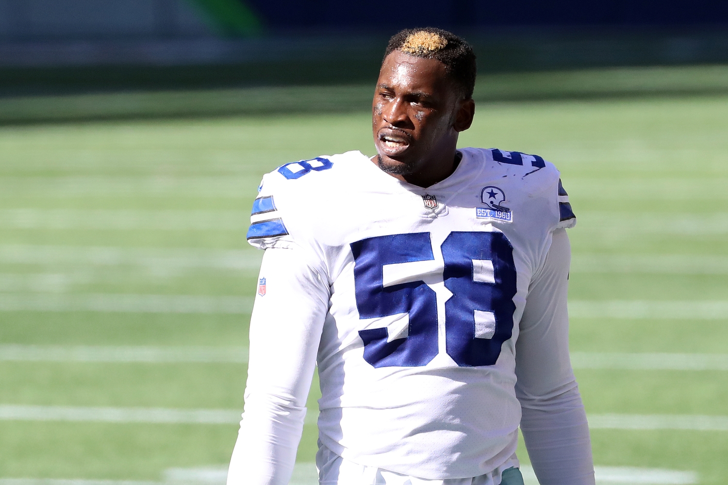Aldon Smith stands with his helmet off during a Dallas Cowboys game.
