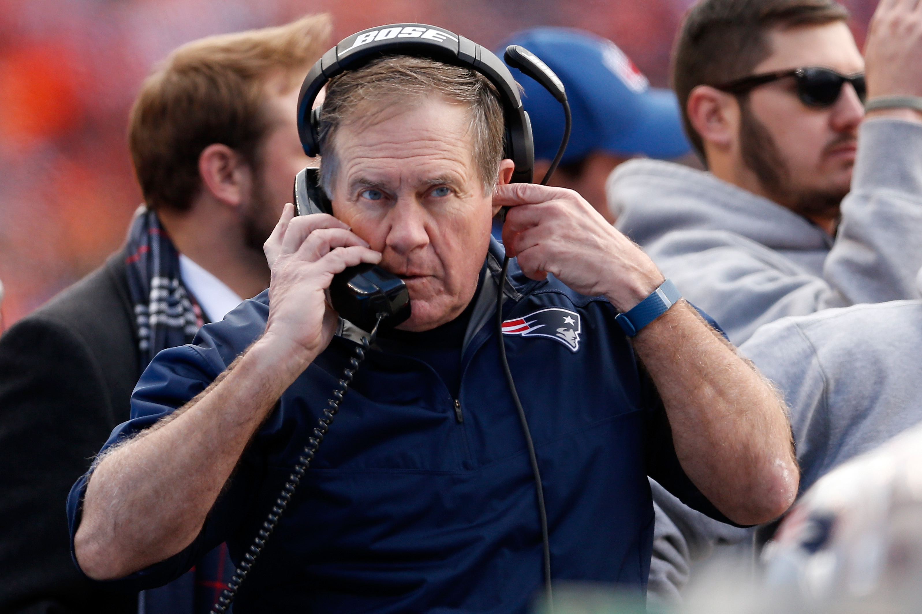 New England Patriots head coach Bill Belichick uses a phone on the sideline.