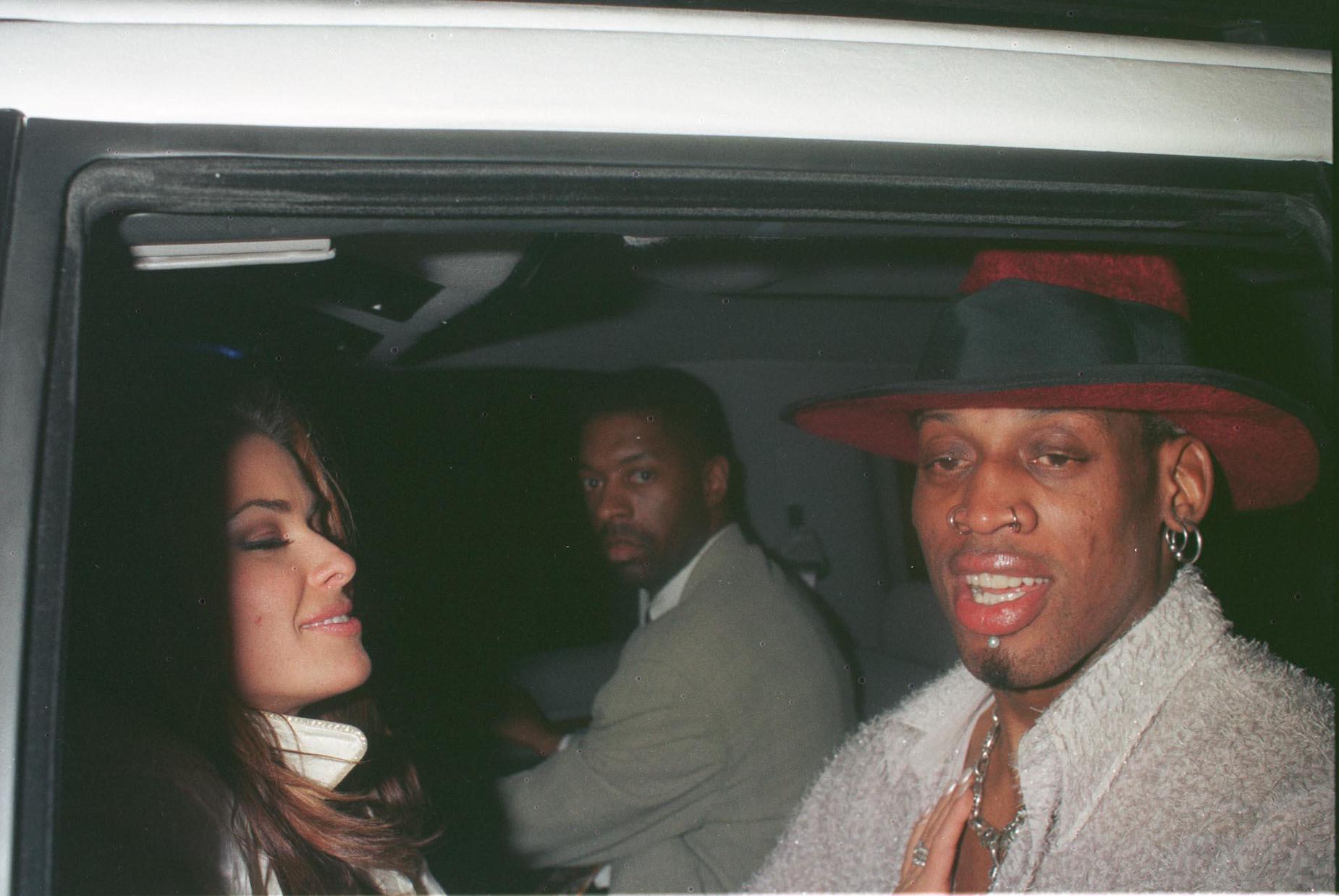 NBA player Dennis Rodman and model Carmen Electra sit in a limousine together in 1999.