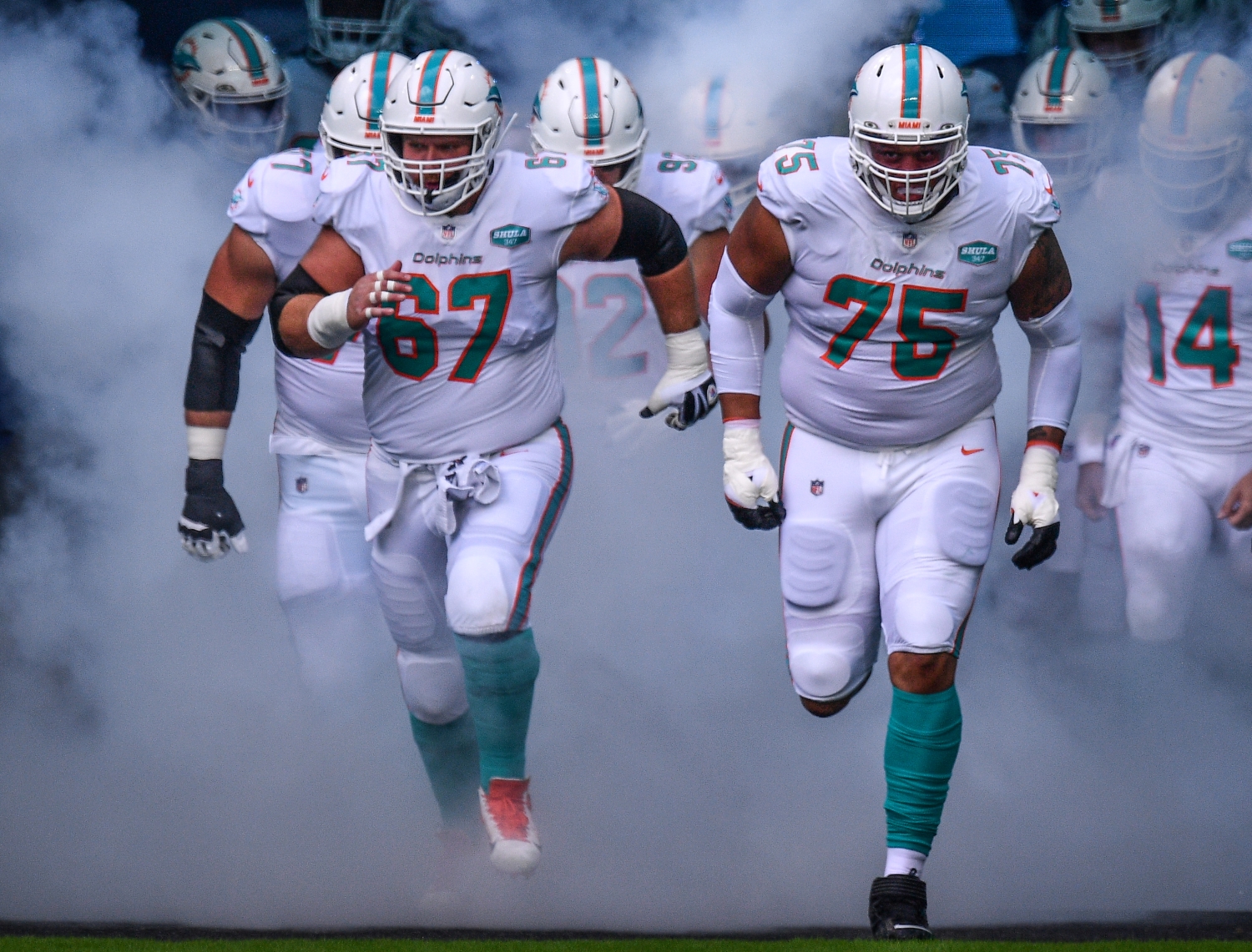 Ted Karras (67) and Ereck Flowers (75) lead the Miami Dolphins out of the tunnel before a game.