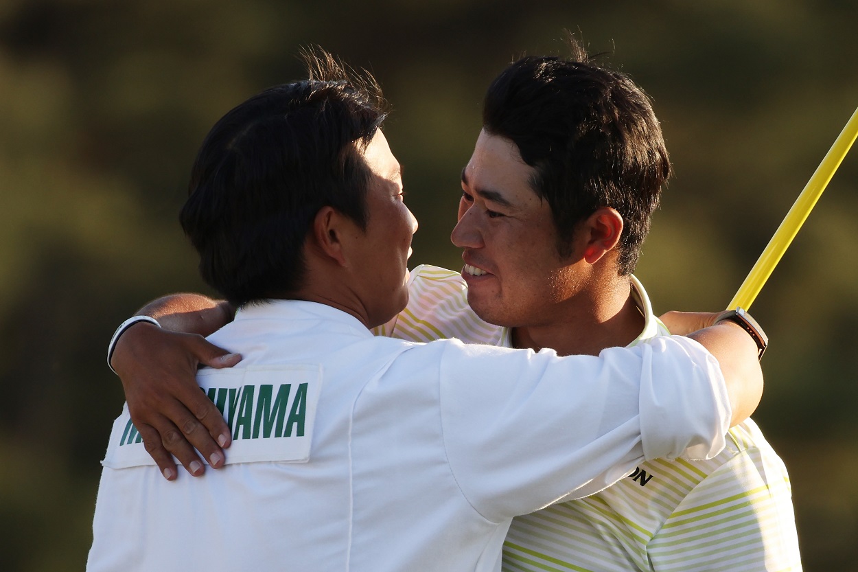 Hideki Matsuyama and caddie Shota Hayafuji embrace after winning the 2021 edition of The Masters