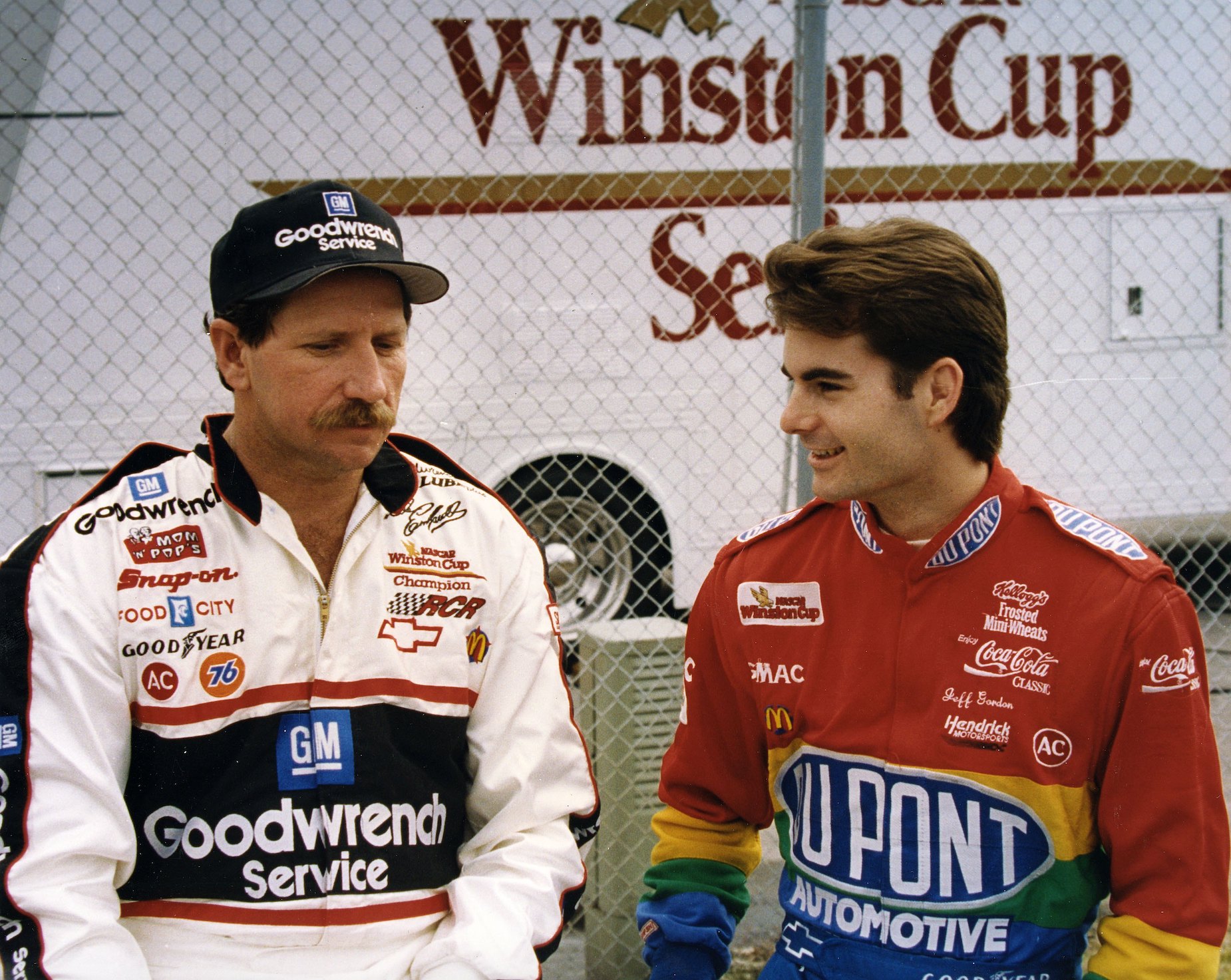 Dale Earnhardt (L) and Jeff Gordon (R) sit together at a race track during the 1990s.