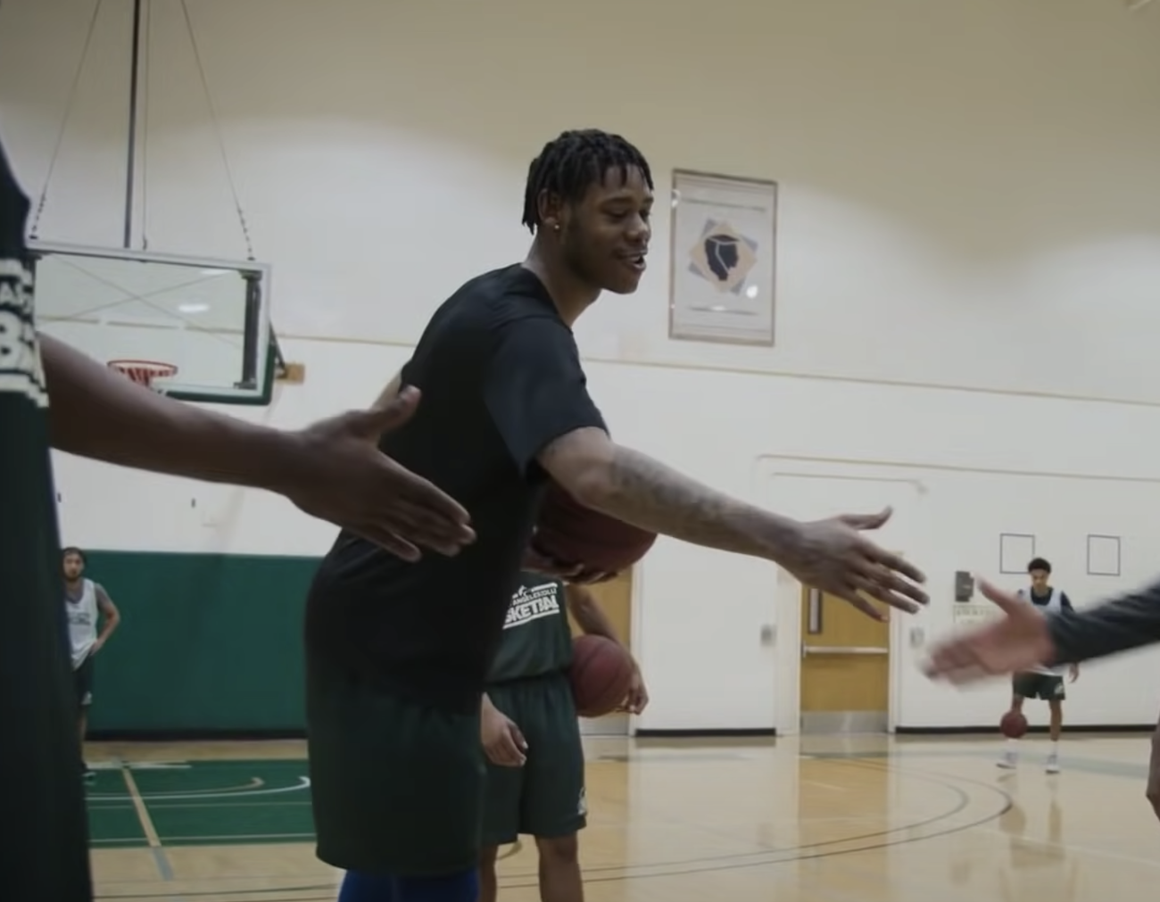Joe Hampton shakes his coach's hand while filming Last Chance U Basketball