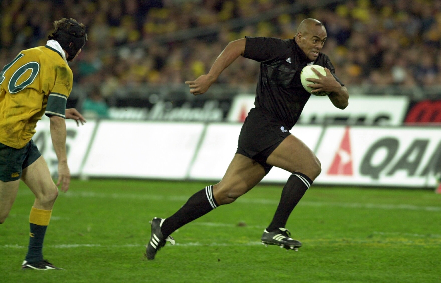 New Zealand All Blacks winger Jonah Lomu runs by an Australian player