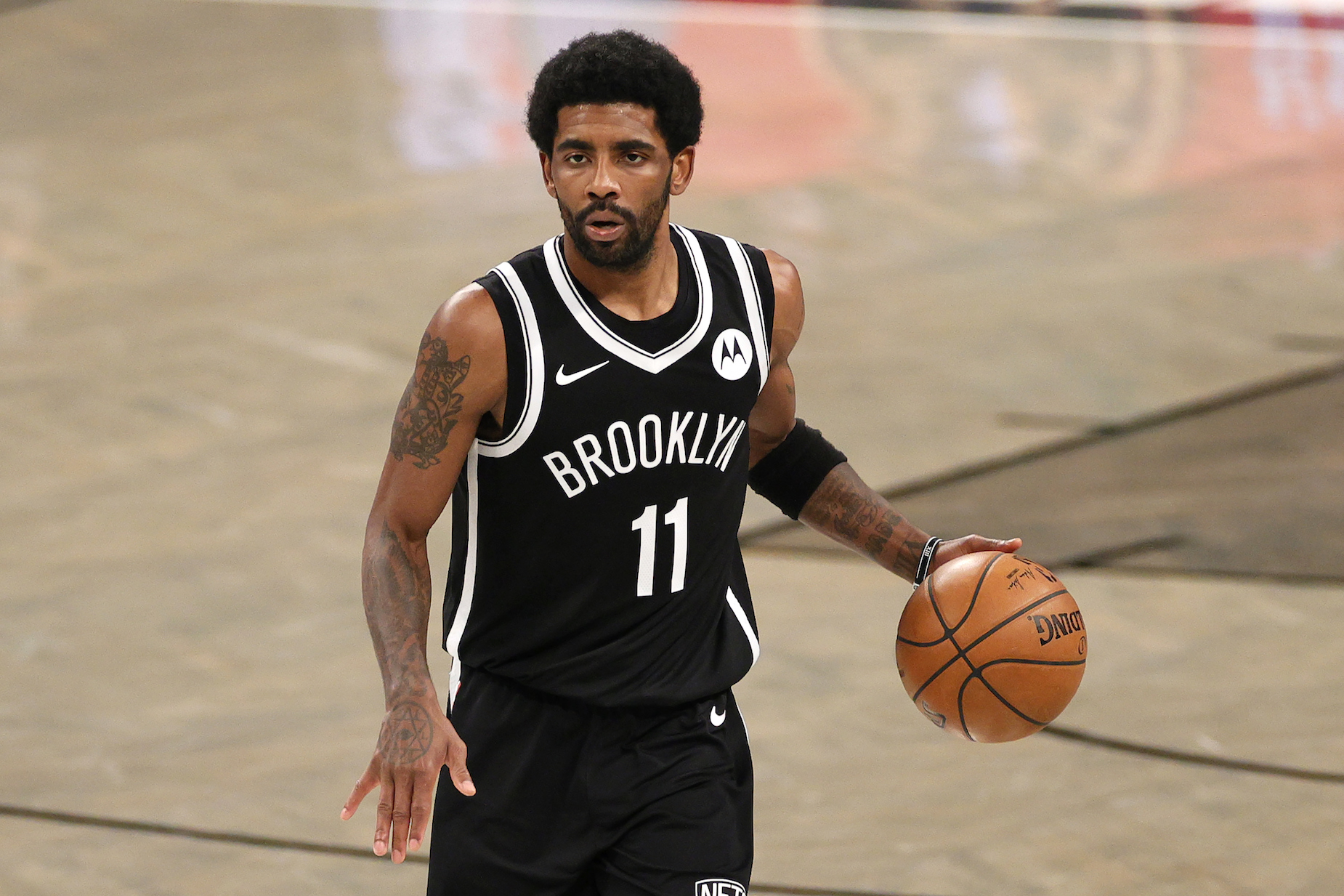 Brooklyn Nets guard Kyrie Irving dribbles the ball in April 2021.