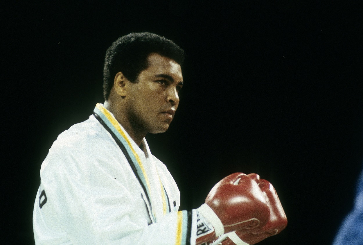 Wearing a white robe, Muhammad Ali holds up his fists prior to a boxing match.