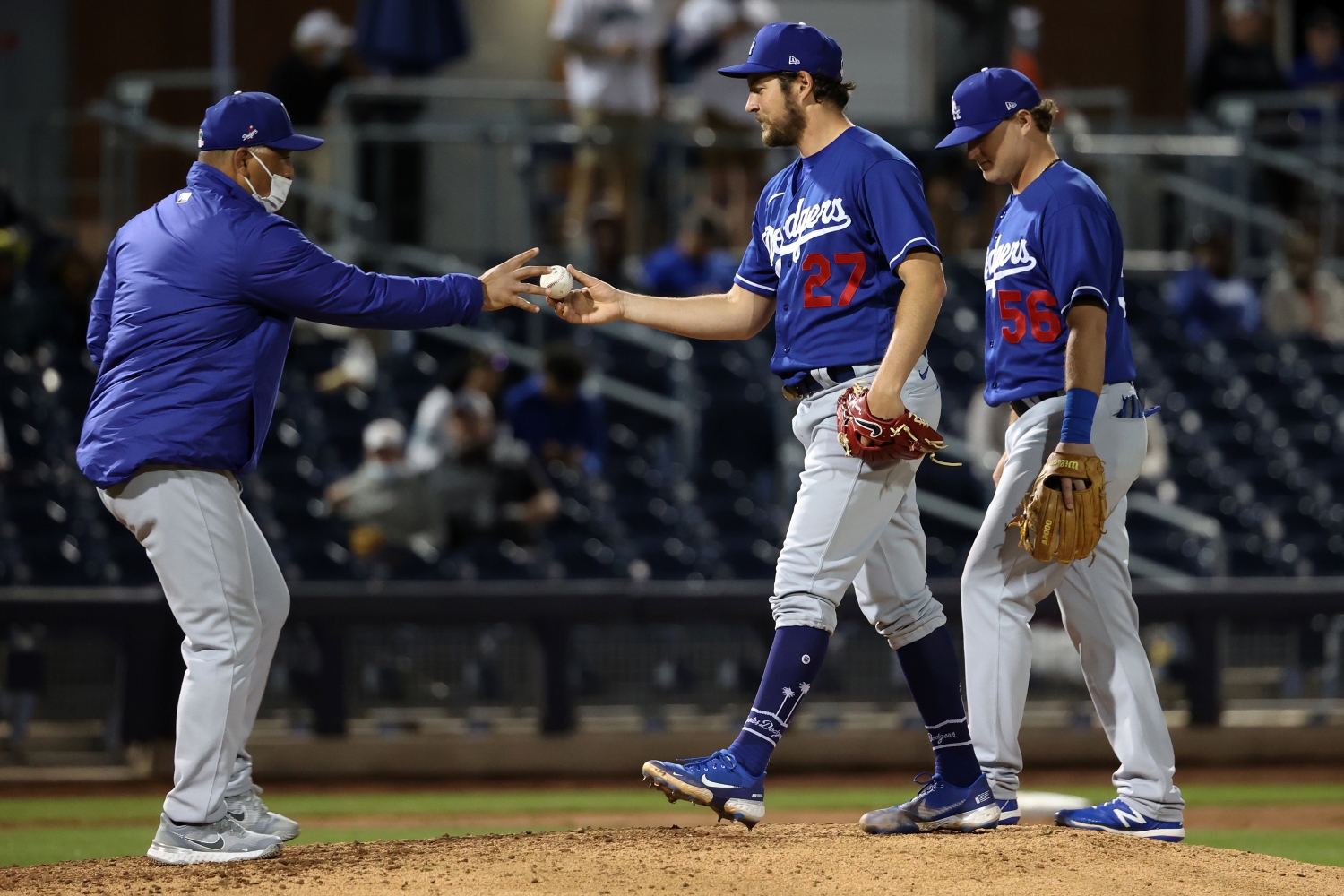LA Dodgers star Trevor Bauer hands the ball to manager Dave Roberts during a spring training game.