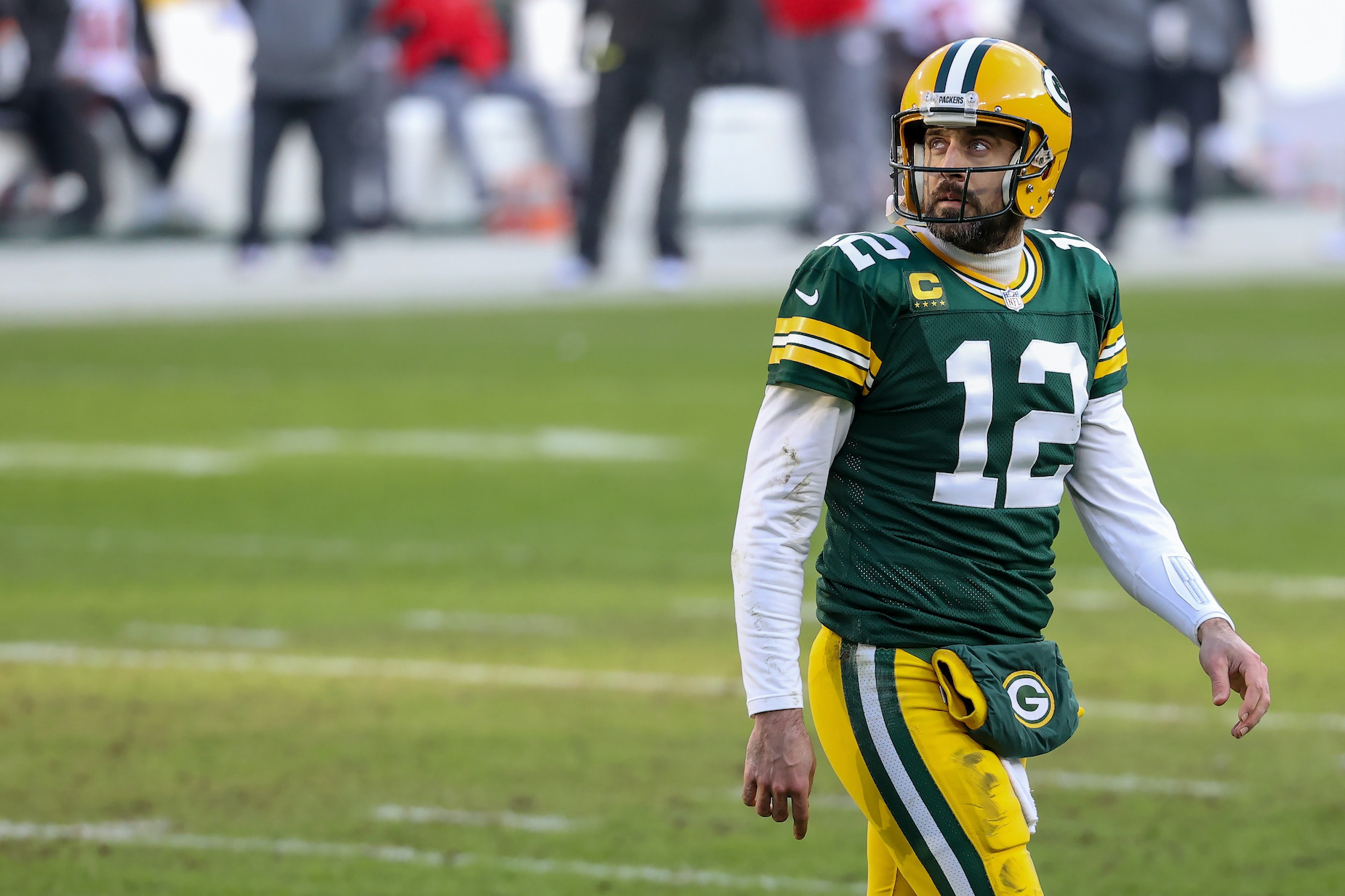Aaron Rodgers walks off the field during a Green Bay Packers playoff game.