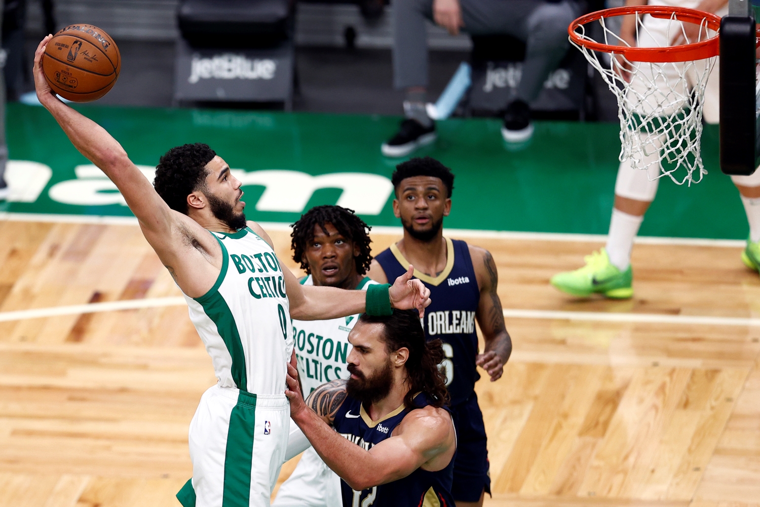 Celtics forward Jayson Tatum dunks the ball during a game.