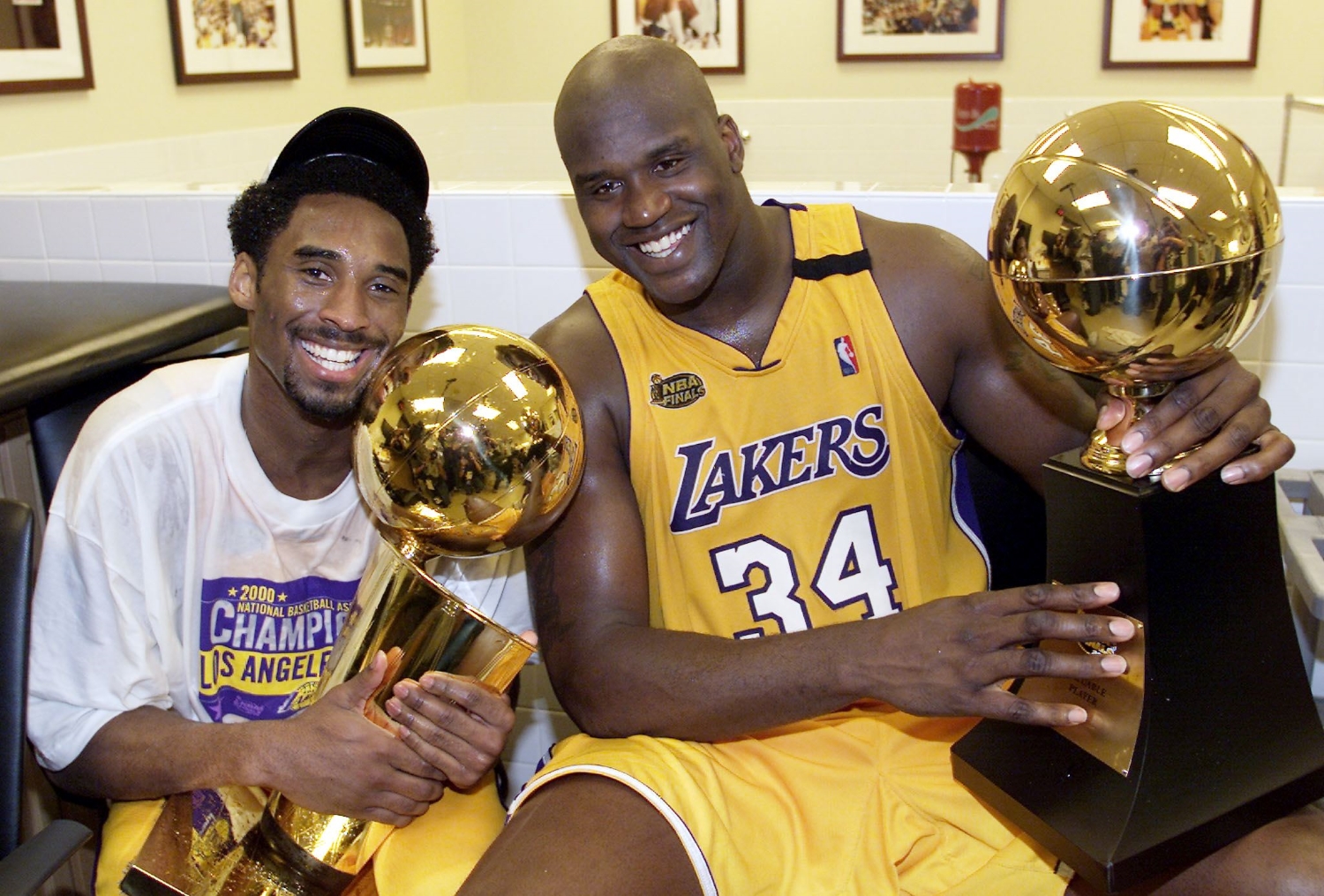 Lakers teammates Kobe Bryant holds the Larry O'Brien Trophy as Shaquille O'Neal holds the NBA Finals MVP trophy.