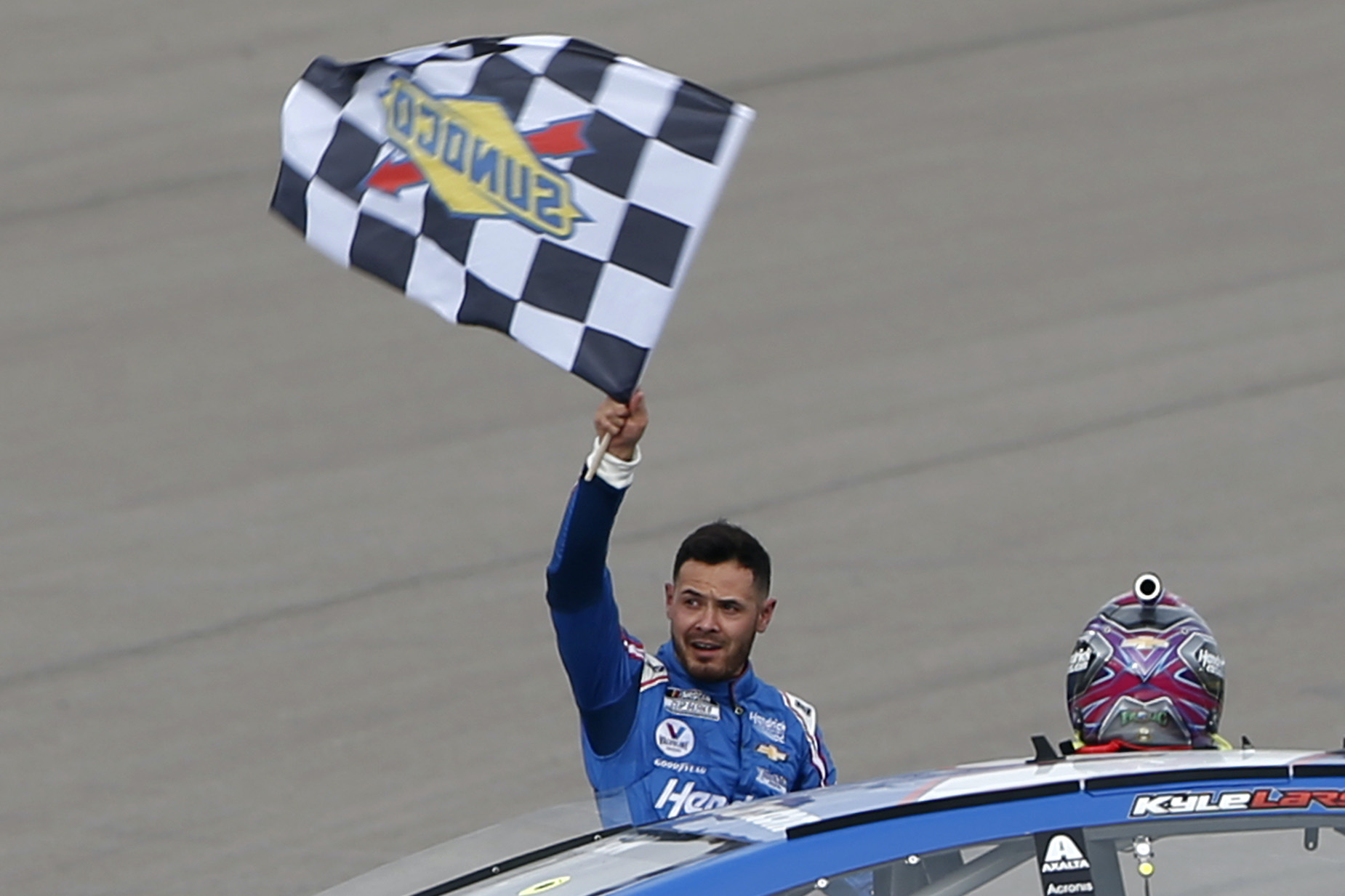 Kyle Larson waves the checkered flag after winning the 2021 NASCAR Cup Series Pennzoil 400.