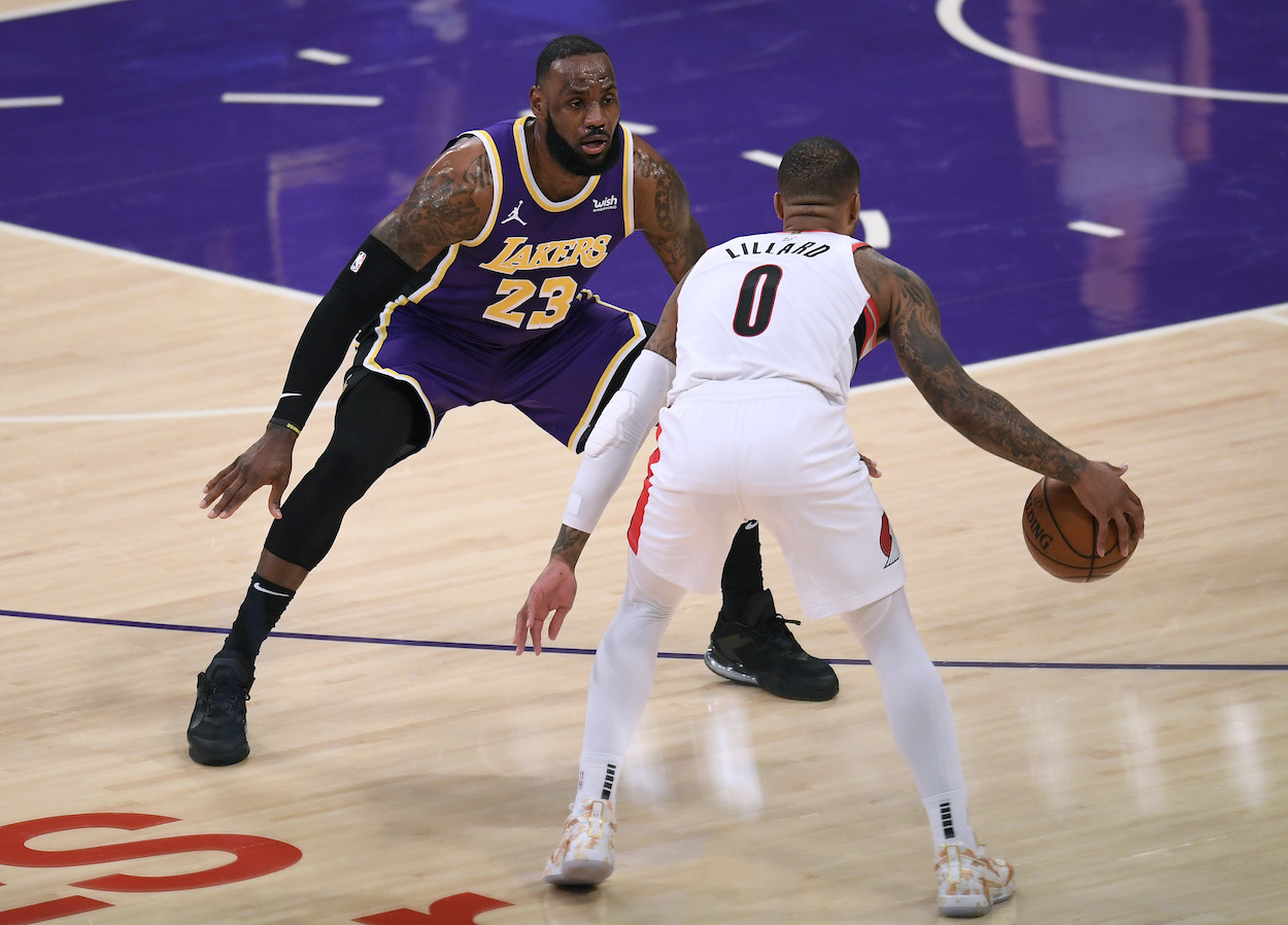 LeBron James of the Los Angeles Lakers guards Damian Lillard of the Portland Trail Blazers during the second quarter at Staples Center on February 26, 2021 in Los Angeles, California.