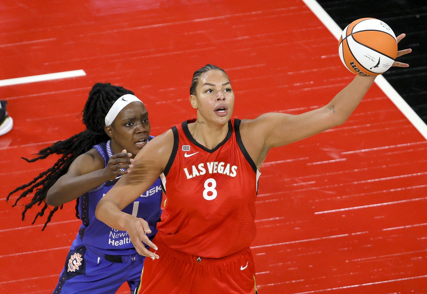 Liz Cambage of the Las Vegas Aces catches a pass under pressure from Beatrice Mompremier of the Connecticut Sun during their game on May 23, 2021 in Las Vegas. | Ethan Miller/Getty Images