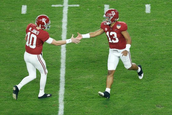 Alabama quarterbacks Mac Jones and Tua Tagovailoa shake hands as Tagavailoa leaves the field.