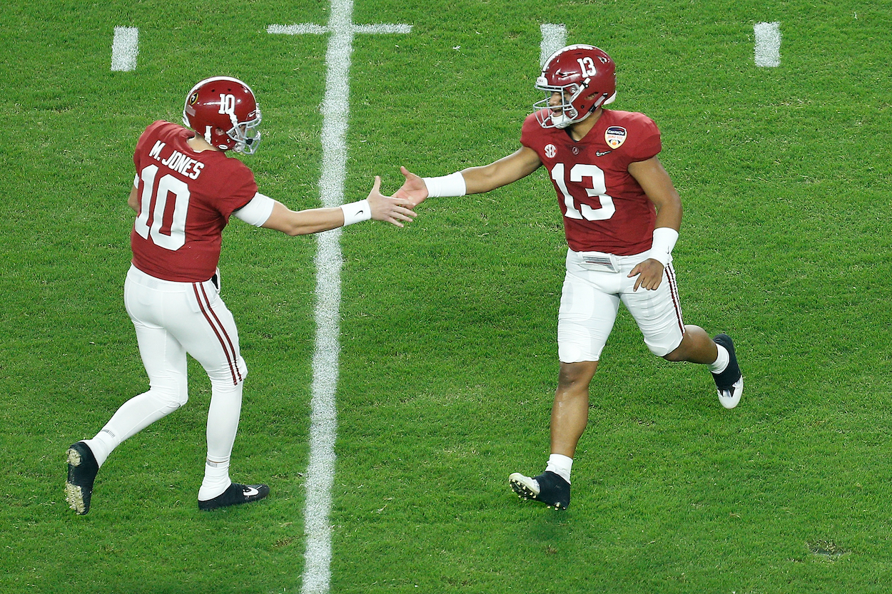 Alabama quarterbacks Mac Jones and Tua Tagovailoa shake hands as Tagavailoa leaves the field.