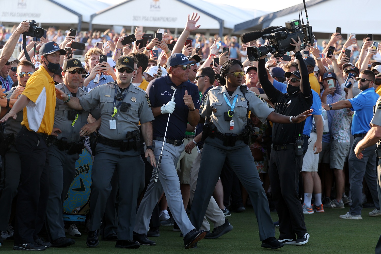 While Brooks Koepka was caught up in the trailing crowd, Phil Mickelson was assisted by security on the 18th fairway during the PGA Championship at Kiawah Island.