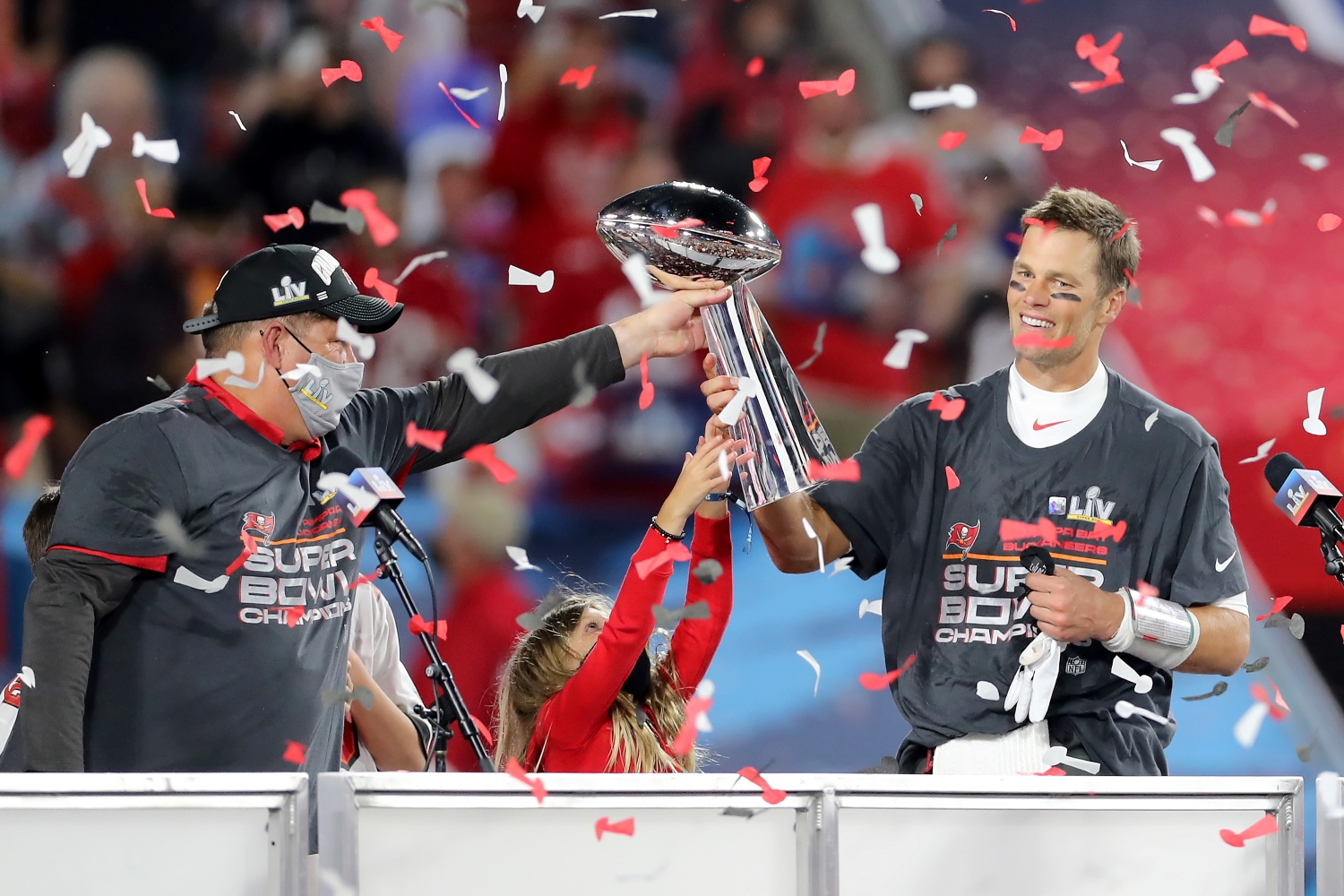 Tampa Bay Buccaneers general manager Jason Licht hands the Lombardi Trophy to Tom Brady.
