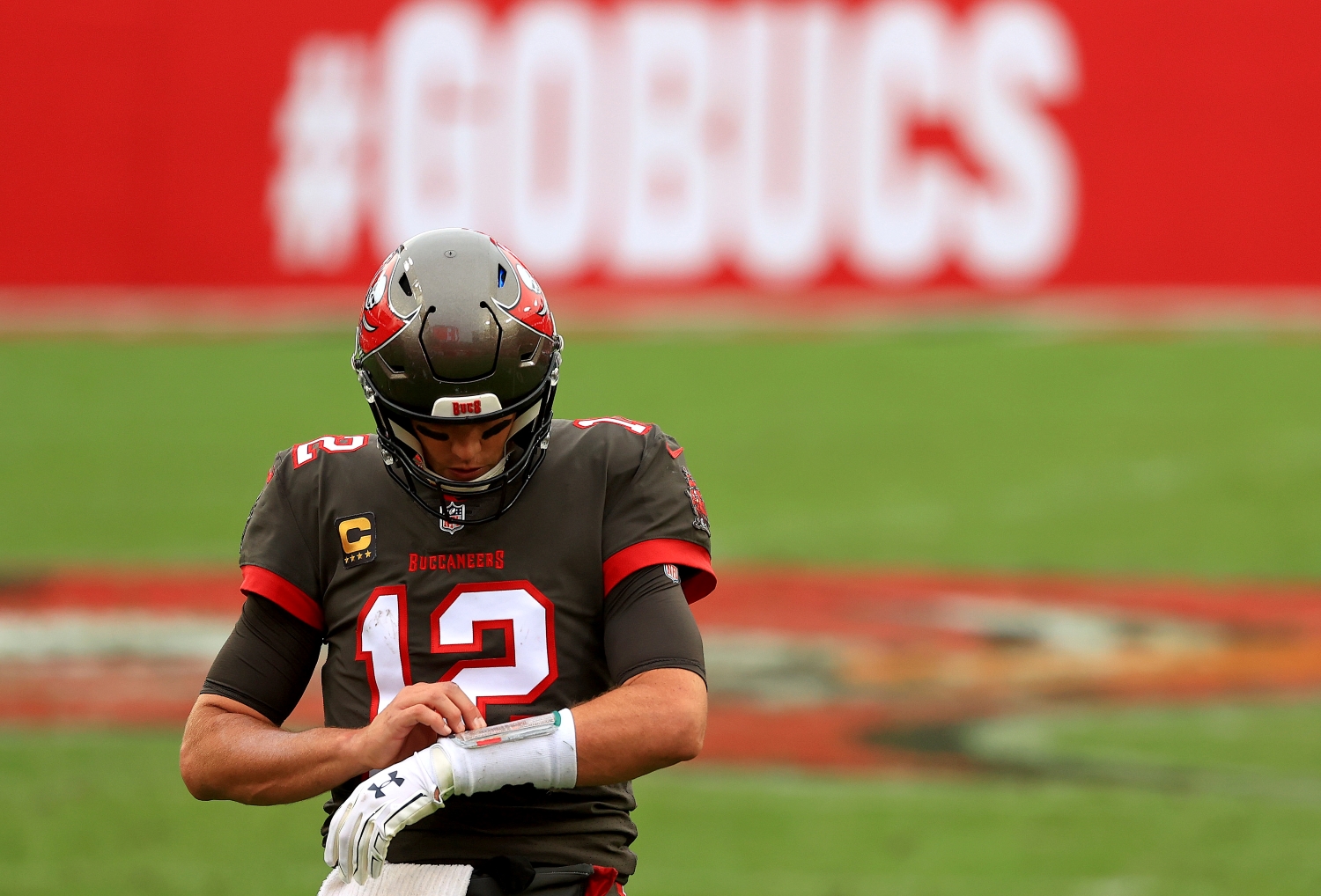 Tampa Bay Buccaneers quarterback Tom Brady looks at his wristband during a game.
