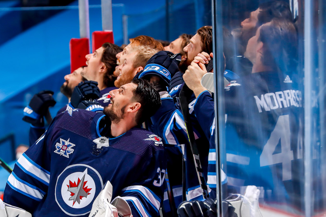 Winnipeg Jets players look on from the bench as they watch a tribute video for teammate Paul Stastny