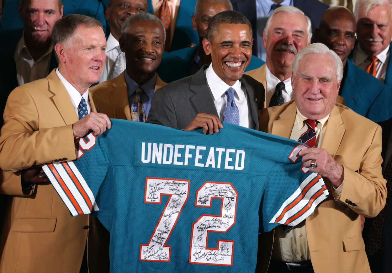 There are seven NFL teams you can make NFL futures bets on to go undefeated in 2021. Here, U.S. President Barack Obama poses for photos with members of the 1972 Miami Dolphins including head coach Don Shula (R), quarterback Bob Griese (L), and running back Larry Csonka (4th L) during an East Room event August 20, 2013 at the White House in Washington, DC.