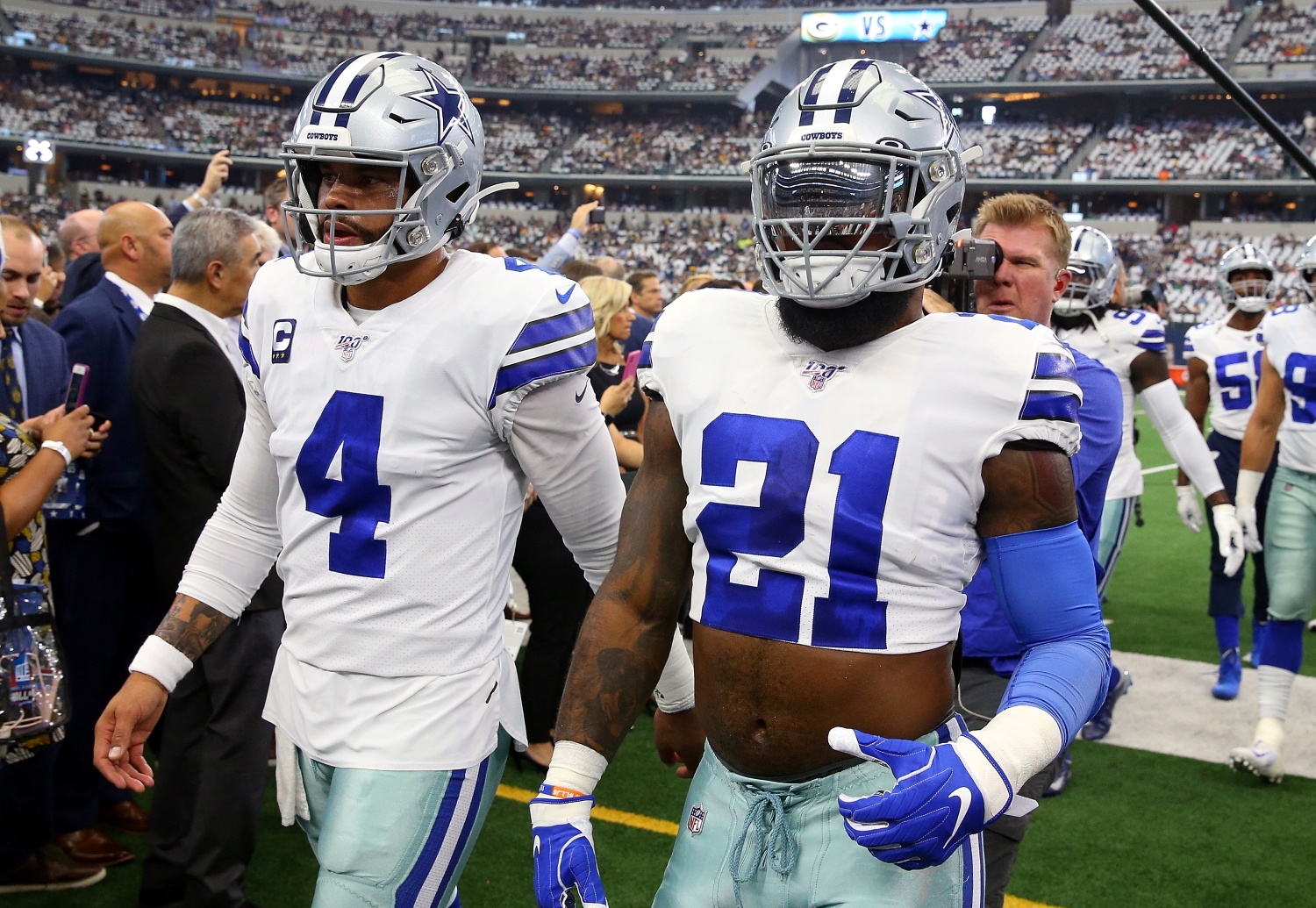 Dallas Cowboys quarterback Dak Prescott walks alongside teammate Ezekiel Elliott as they exit the field.