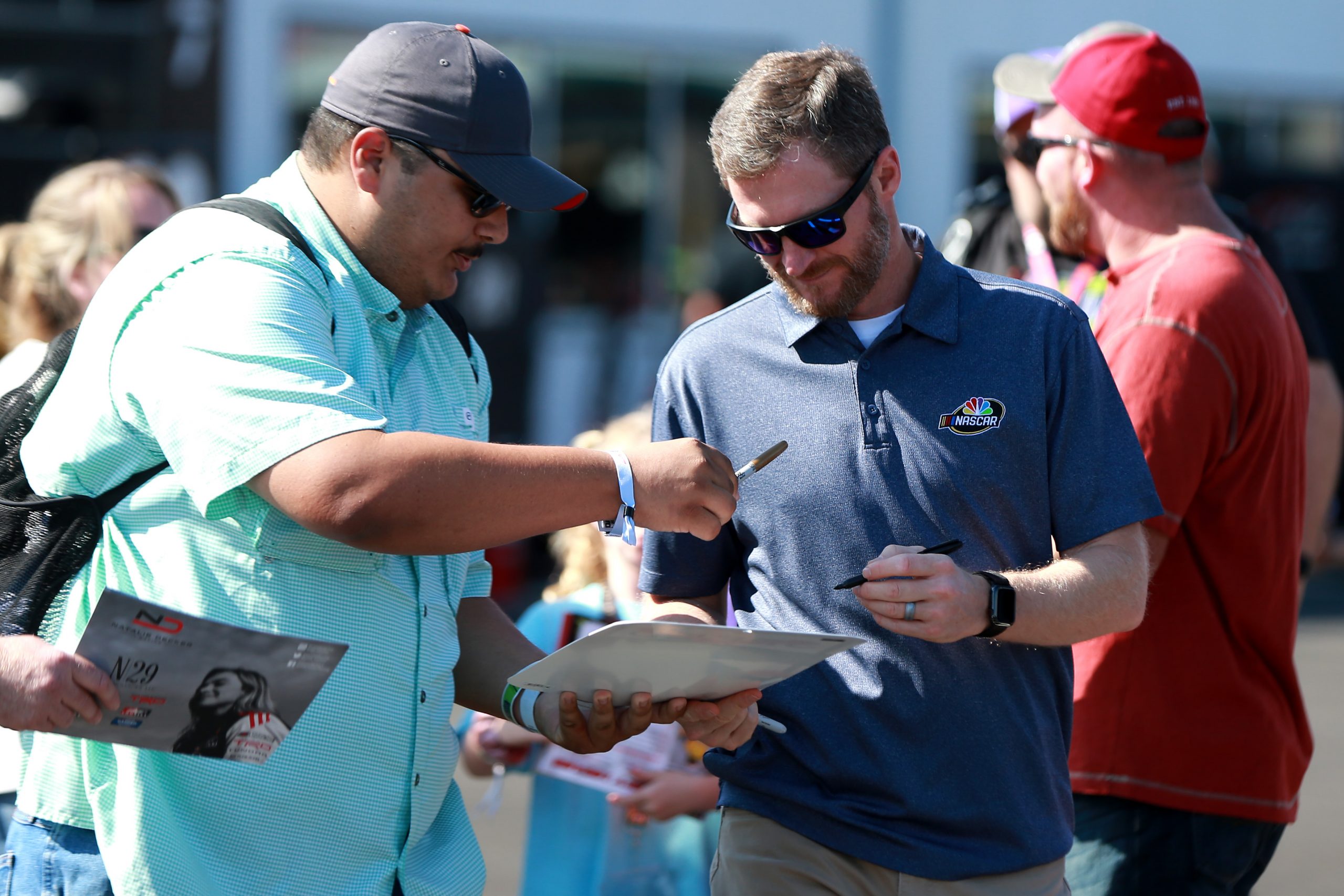Dale Earnhardt Jr. signs an autograph for a fan.