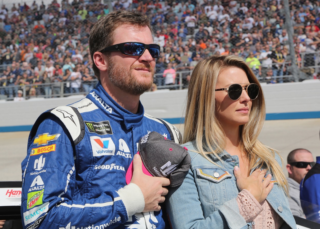 Dale Earnhardt Jr. and his wife Amy Earnhardt stand on the NASCAR track before a race.