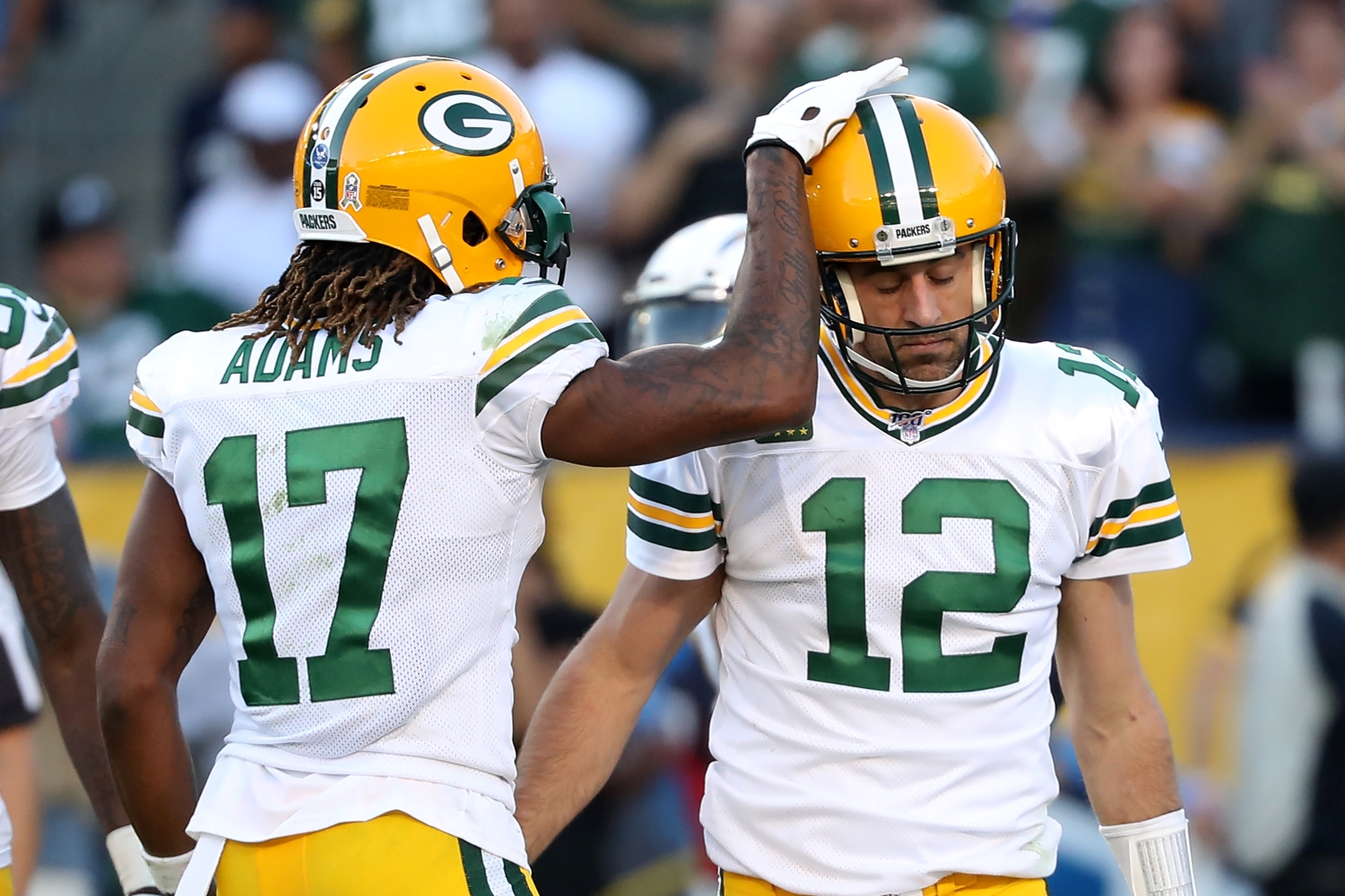 Davante Adams taps Aaron Rodgers on the helmet after a play.
