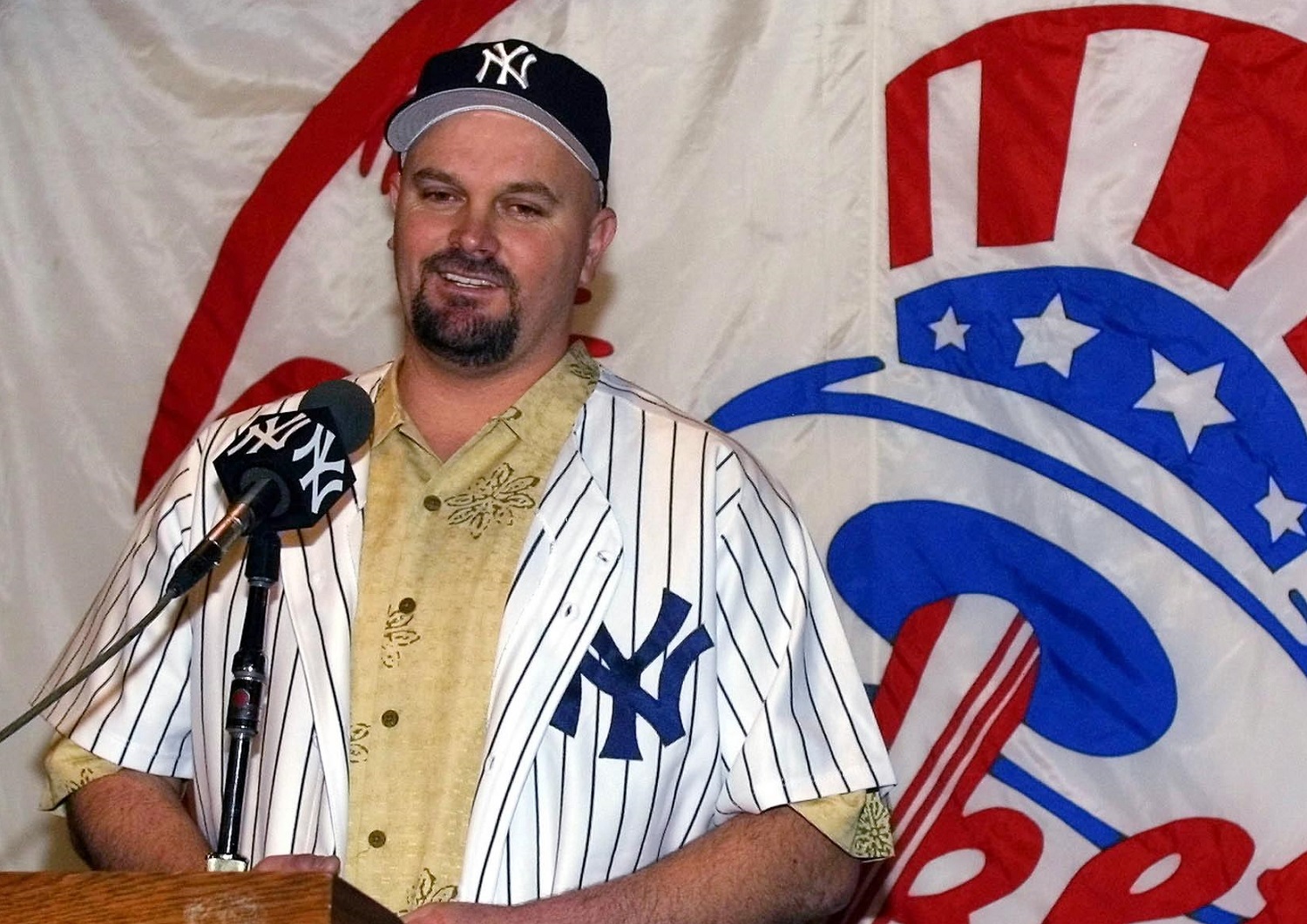 Left-hander David Wells smiles as he answers questions at a news conference announcing his signing for the second time with the Yankees in January 2002 at Yankee Stadium. | Matt Campbell/AFP via Getty Images