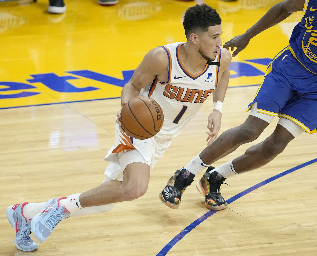 Devin Booker of the Phoenix Suns dribbling the ball drives towards the basket against the Golden State Warriors during the second half of an NBA basketball game at Chase Center on May 11, 2021 in San Francisco, California.