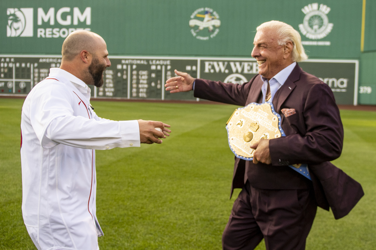 Former Red Sox player Dustin Pedroia and Ric Flair get ready to embrace Friday night at Fenway Park.