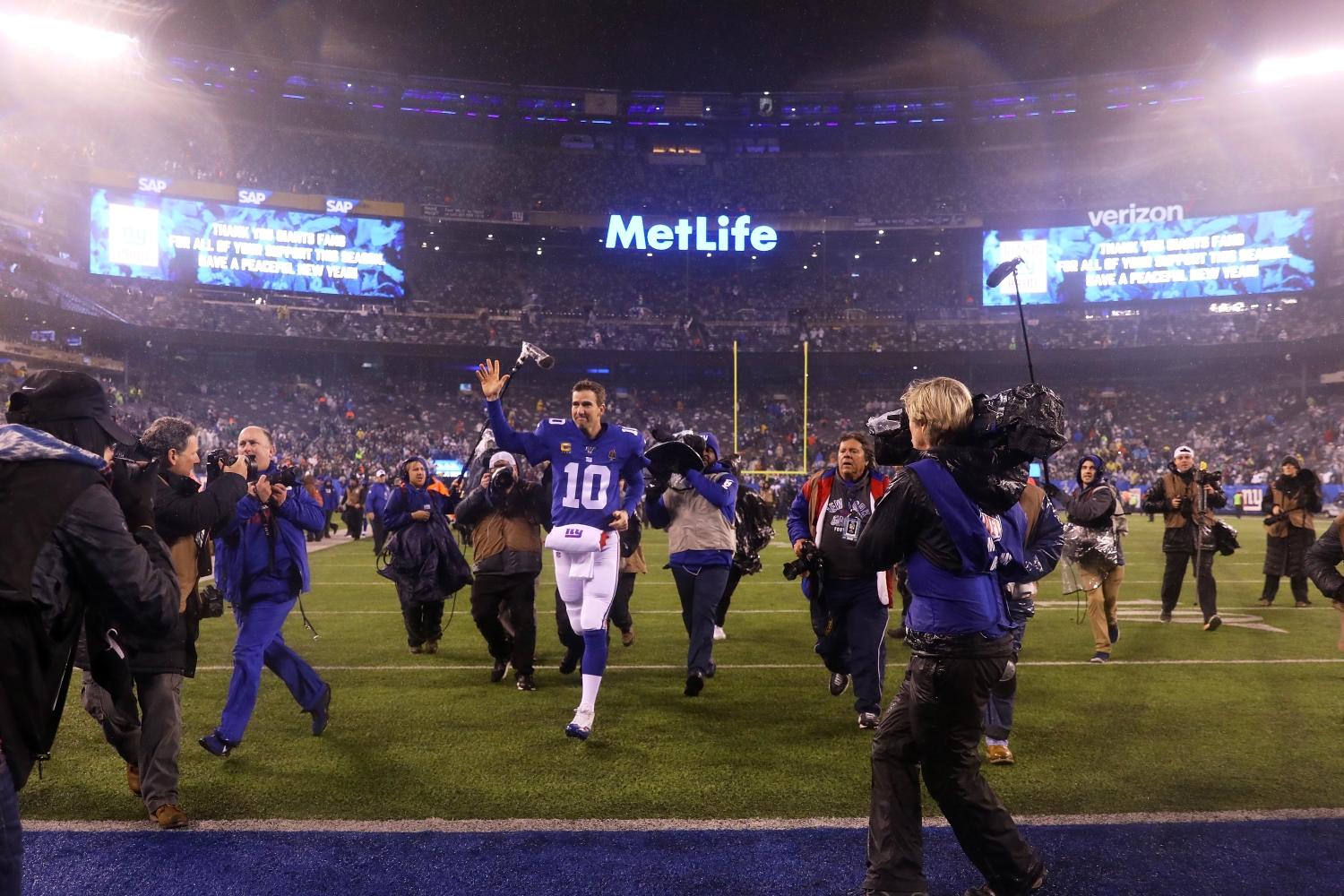 Eli Manning waves to the crowd as he exits the field after his final game as a member of the New York Giants.