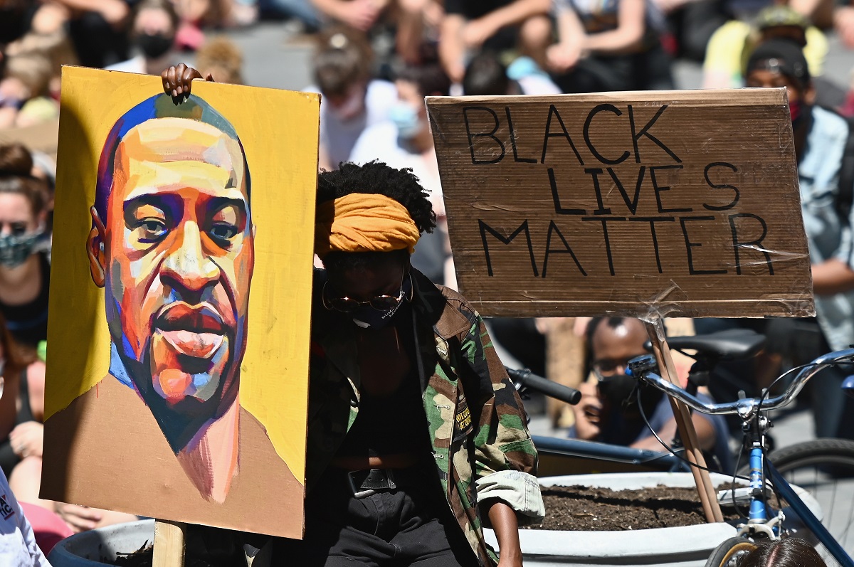 Protesters at a Black Lives Matter Rally holding up a picture of George Floyd.