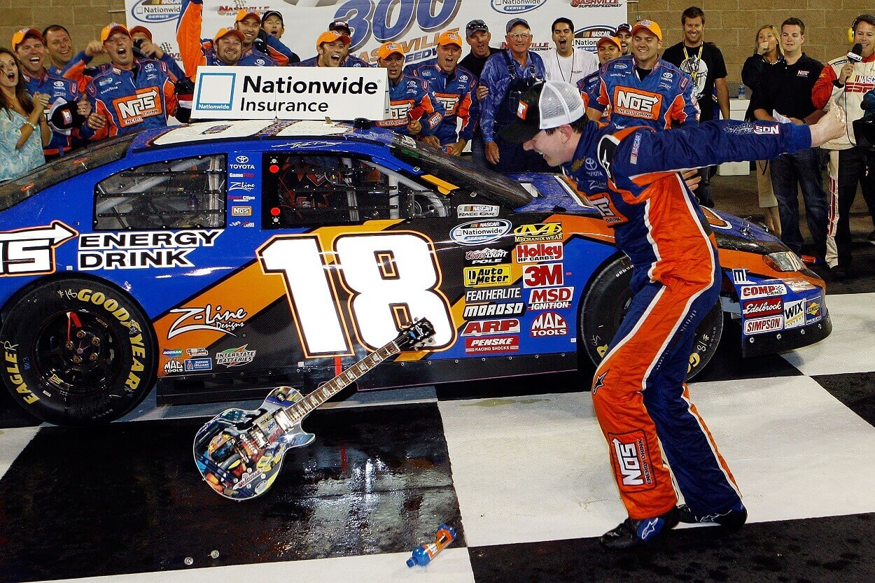 Kyle Busch, driver of the #18 NOS Energy Drink Toyota celebrates by smashing the Gibson Guitar given to the winner after winning the NASCAR Nationwide Series Federated Auto Parts 300 at the Nashville Superspeedway on June 6, 2009 in Lebanon,Tennessee