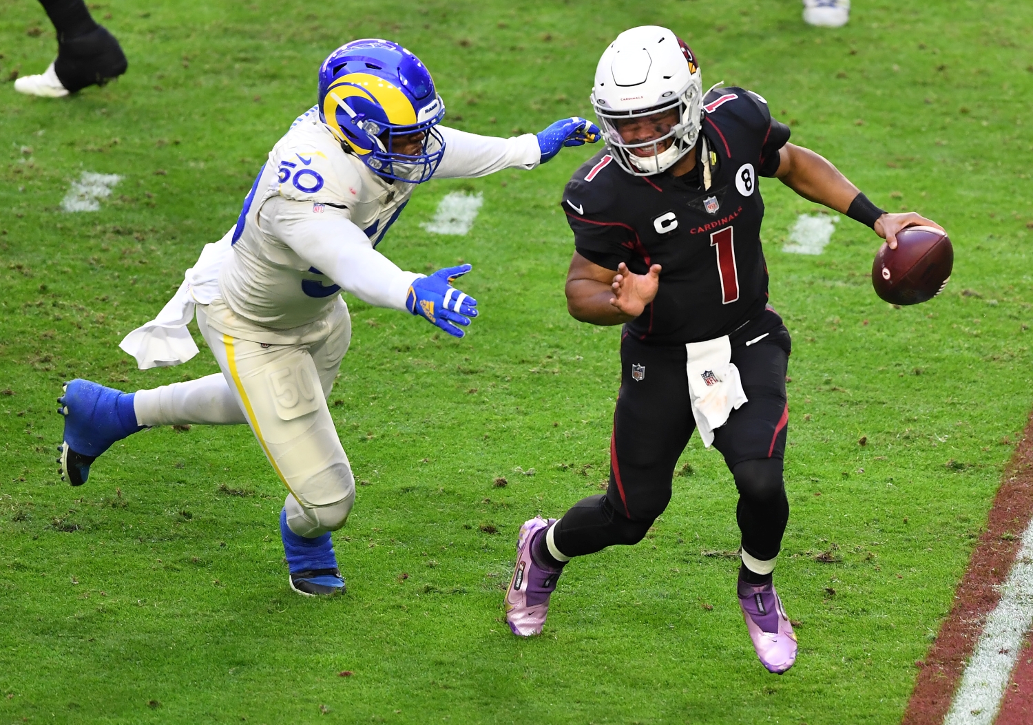 Arizona Cardinals quarterback Kyler Murray tries to avoid getting tackled by an LA Rams defender.