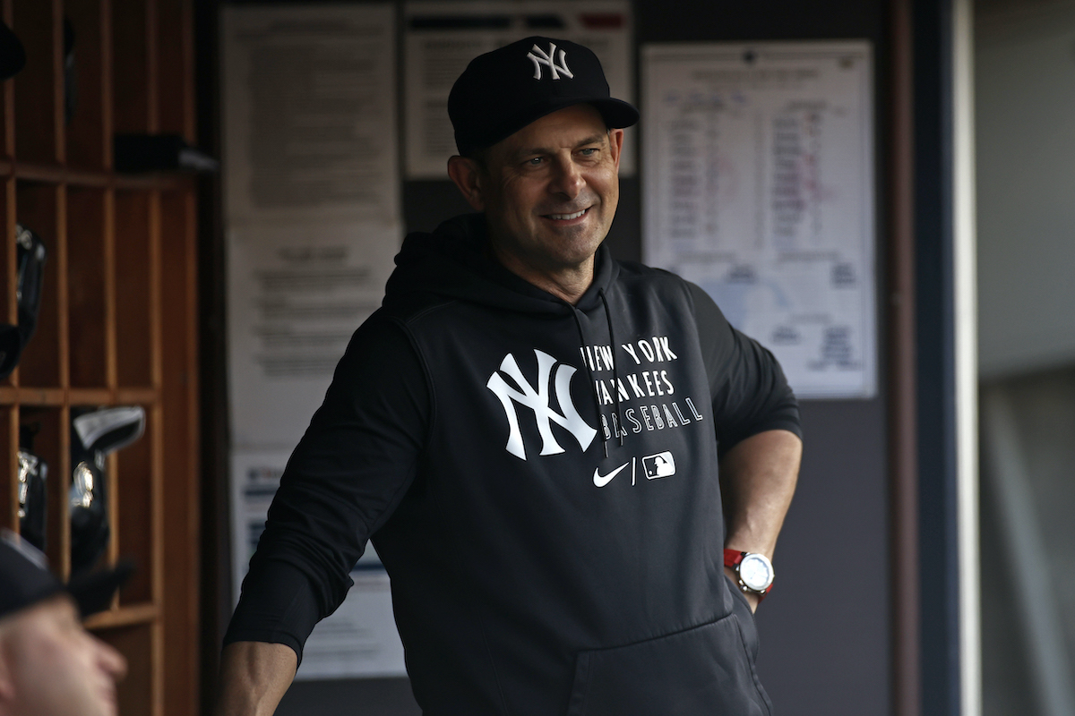 Aaron Boone of the New York Yankees stands in the dugout and smiles