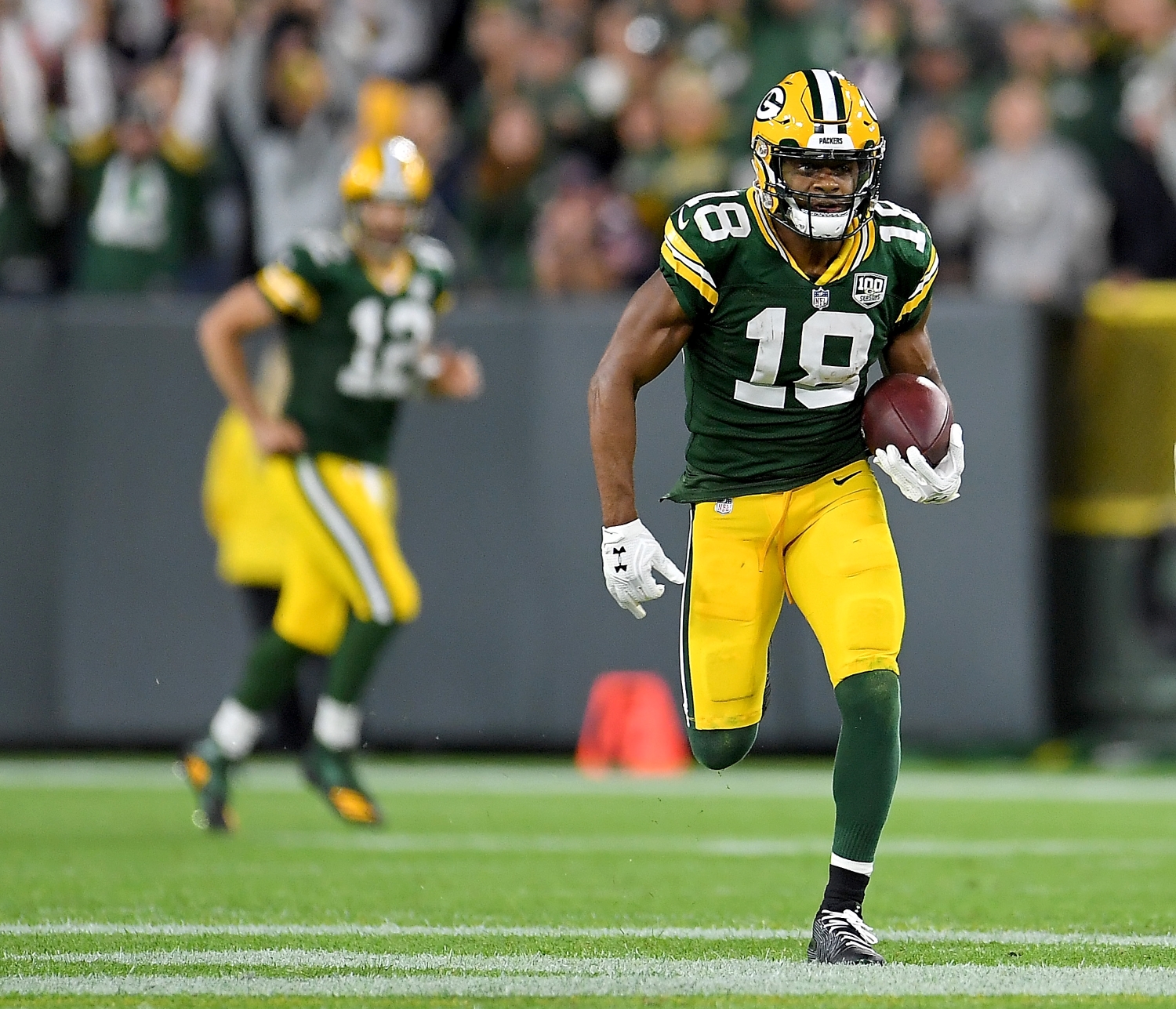 Aaron Rodgers watches Green Bay Packers receiver Randall Cobb run down the field with the ball in his hands.