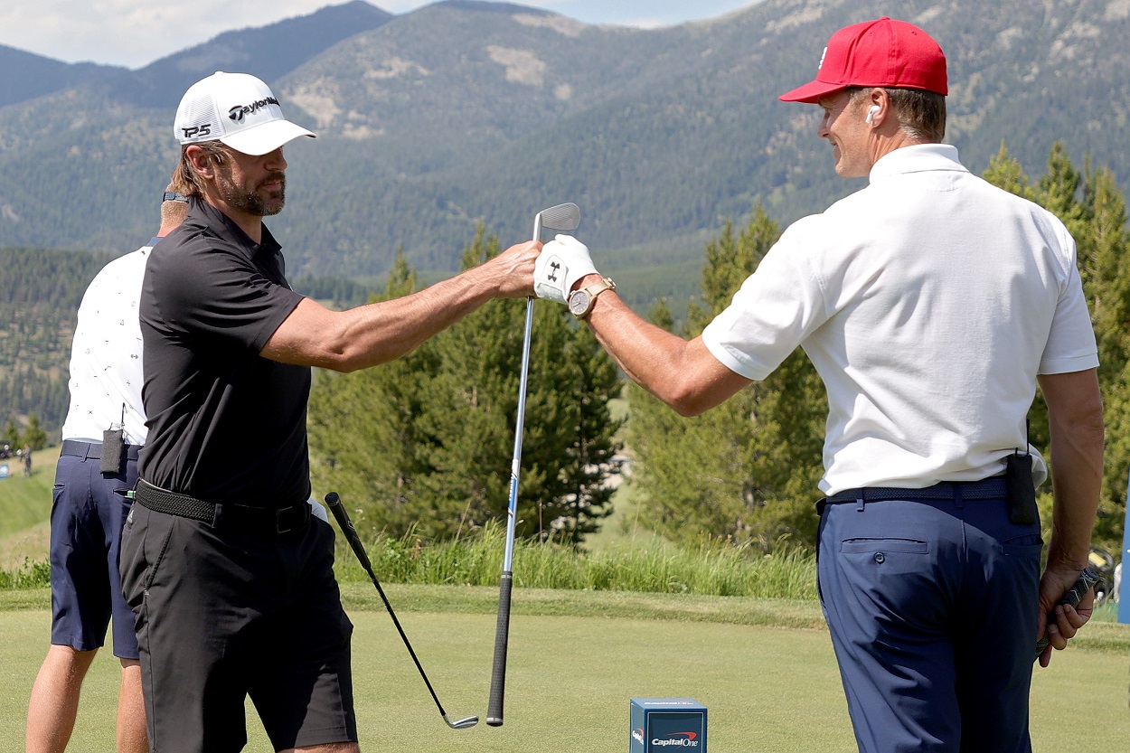 Aaron Rodgers and Tom Brady bump fists during 'The Match' in Big Sky, Montana