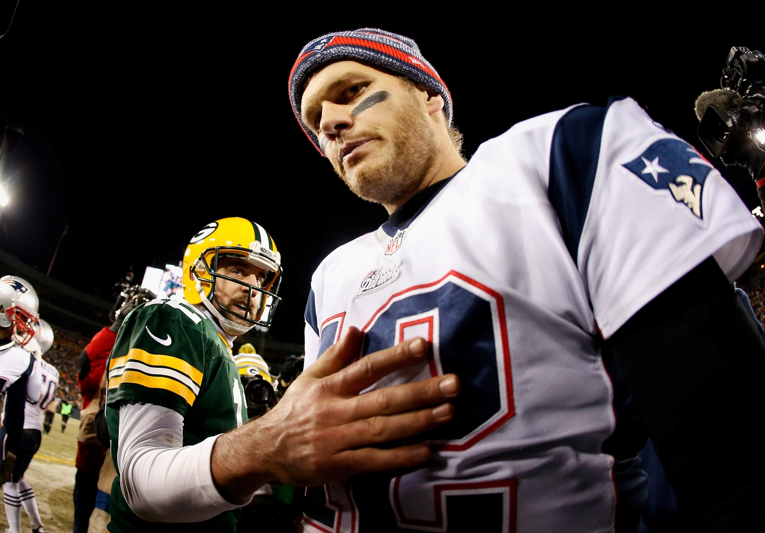 New England Patriots QB Tom Brady walks away from Green Bay Packers QB Aaron Rodgers after they shake hands.