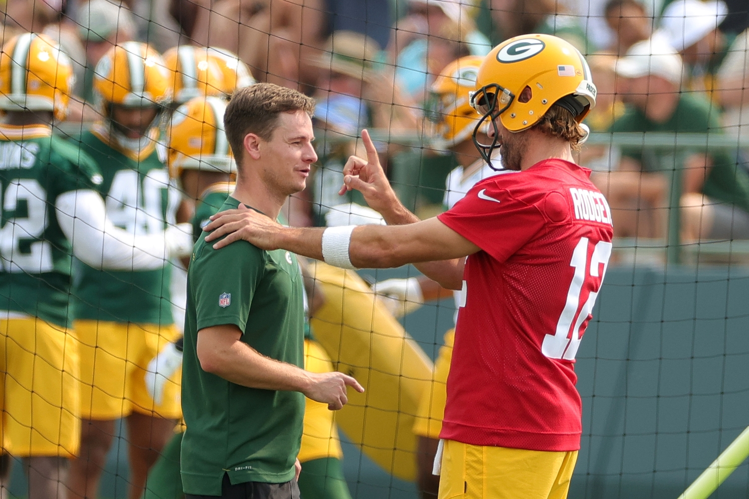 Aaron Rodgers speaks to a Packers staff member during training camp practice.