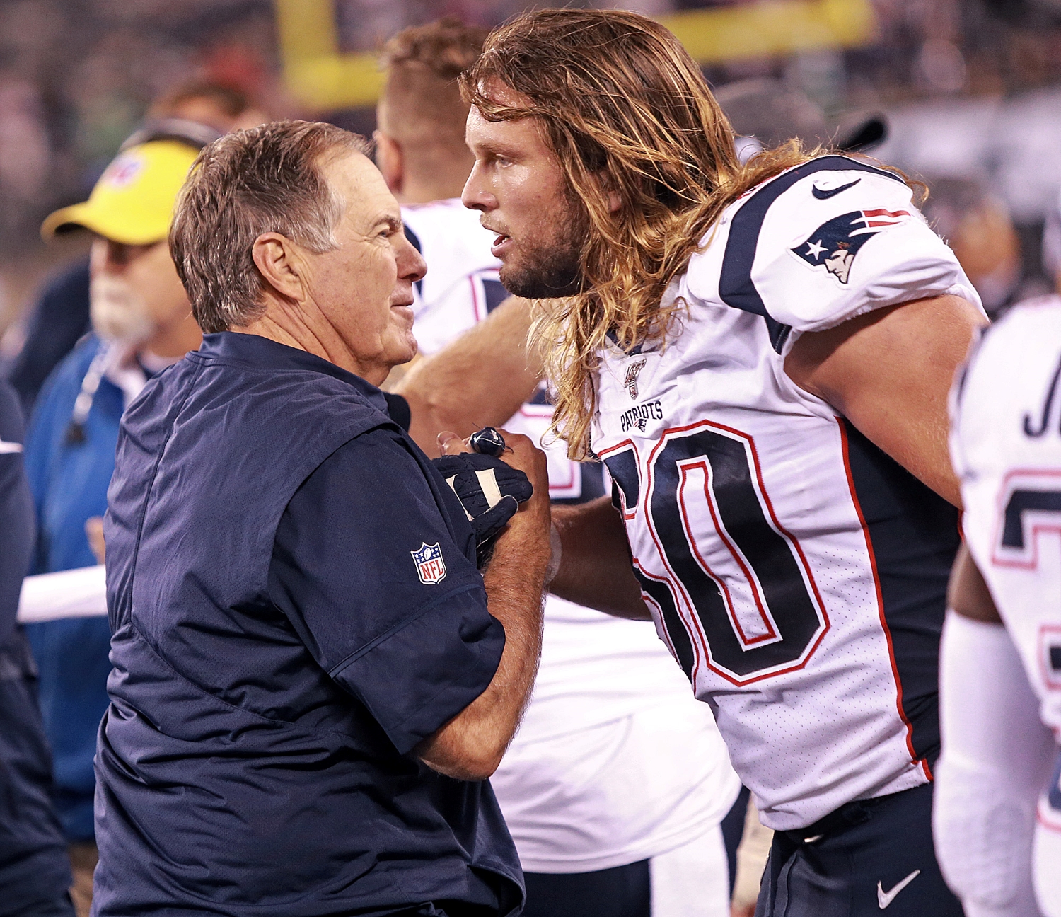 New England Patriots head coach Bill Belichick embraces linebacker Chase Winovich.