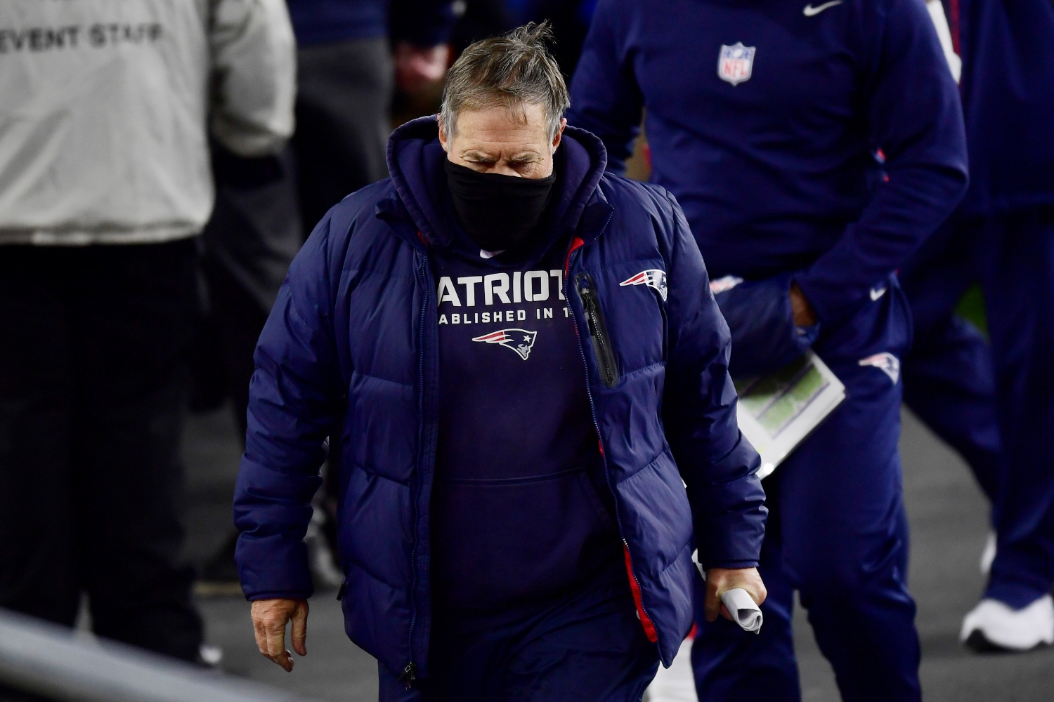 New England Patriots head coach Bill Belichick looks down on the sidelines during a game.