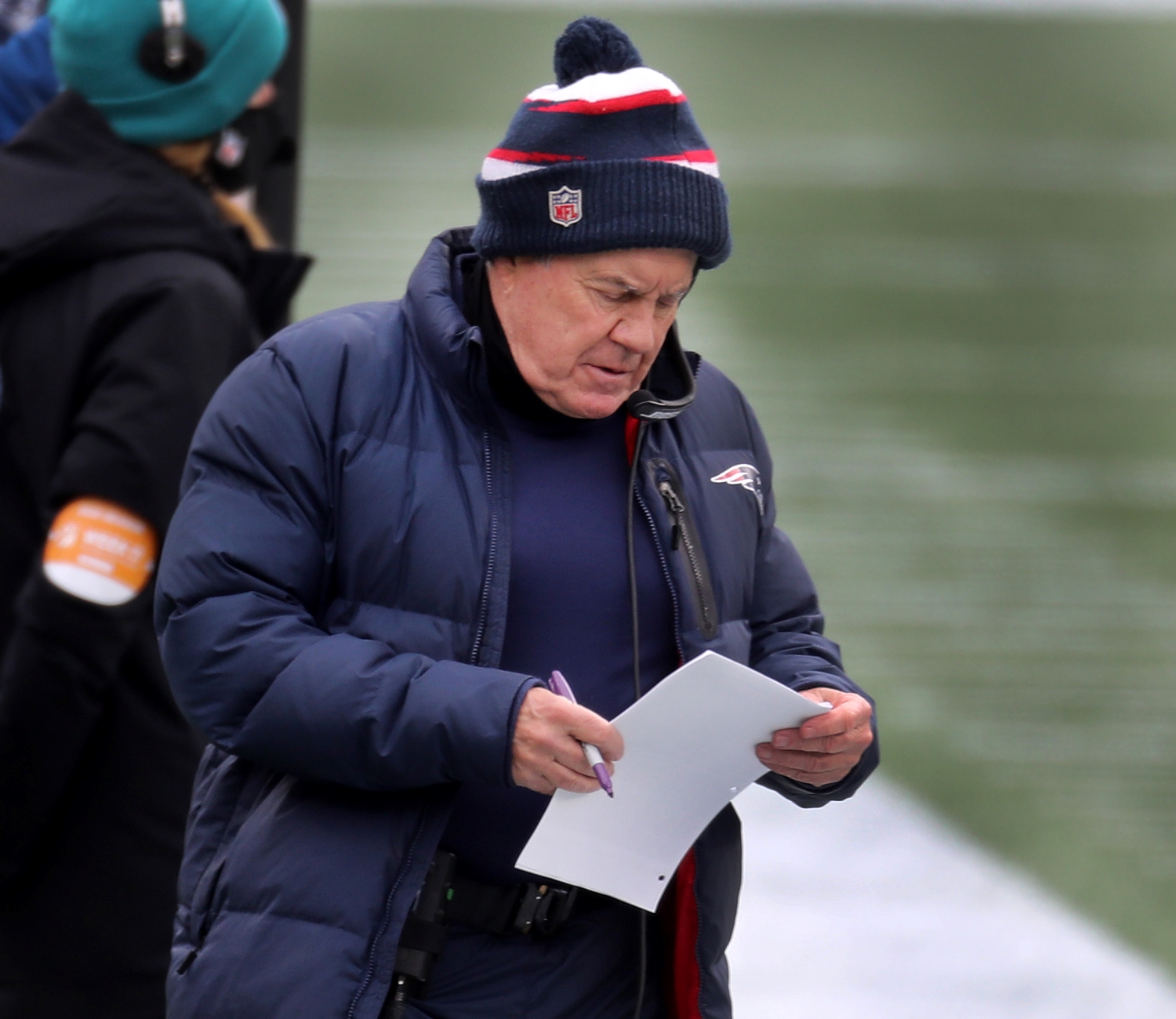 New England Patriots coach Bill Belichick reviews a play sheet during a game.
